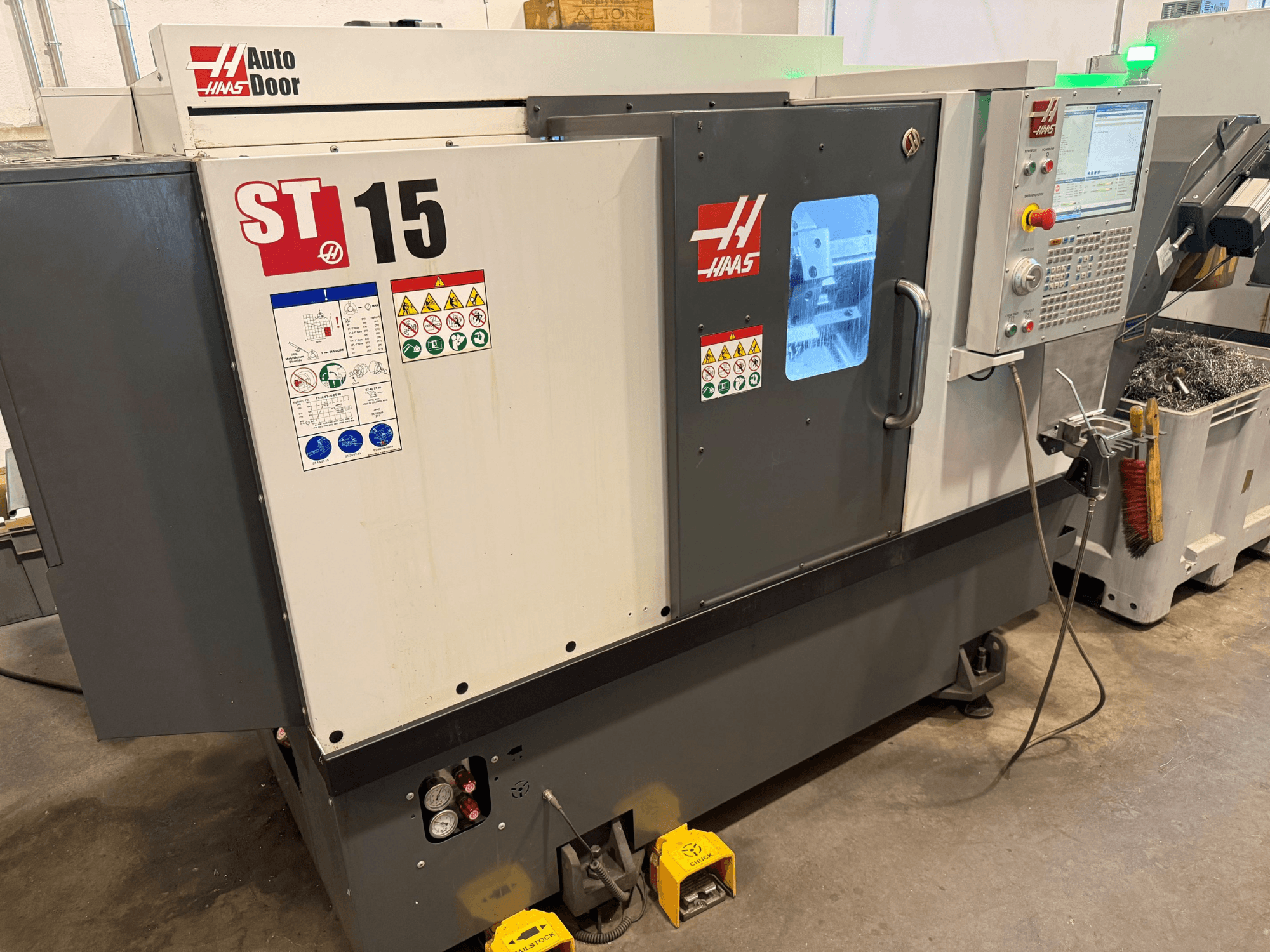 HAAS ST 15 horisontell svarv, framifrån med kontrollpanelen, den automatiska luckan och de synliga tekniska indikatorerna.