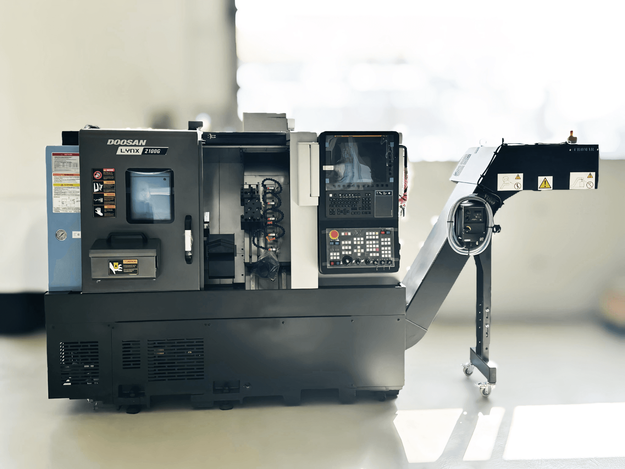 DOOSAN LYNX 2100GA svarv av schweizisk typ i sidovy med kontrollpanel och verktygshållare synliga.