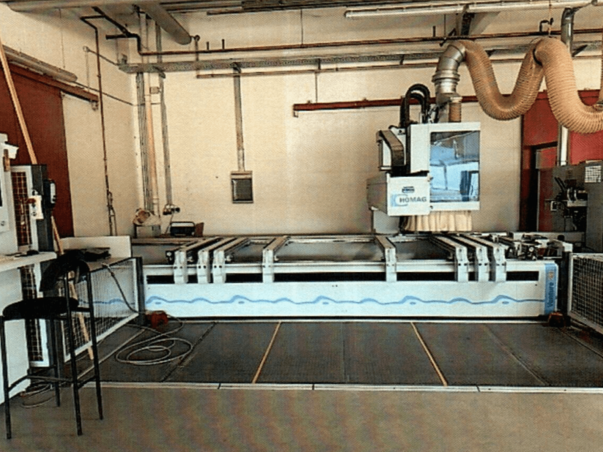HOMAG BAZ 211/40K CNC-bearbetningscenter för trä i en verkstad, där maskinens kontrollpanel och skärområde visas.