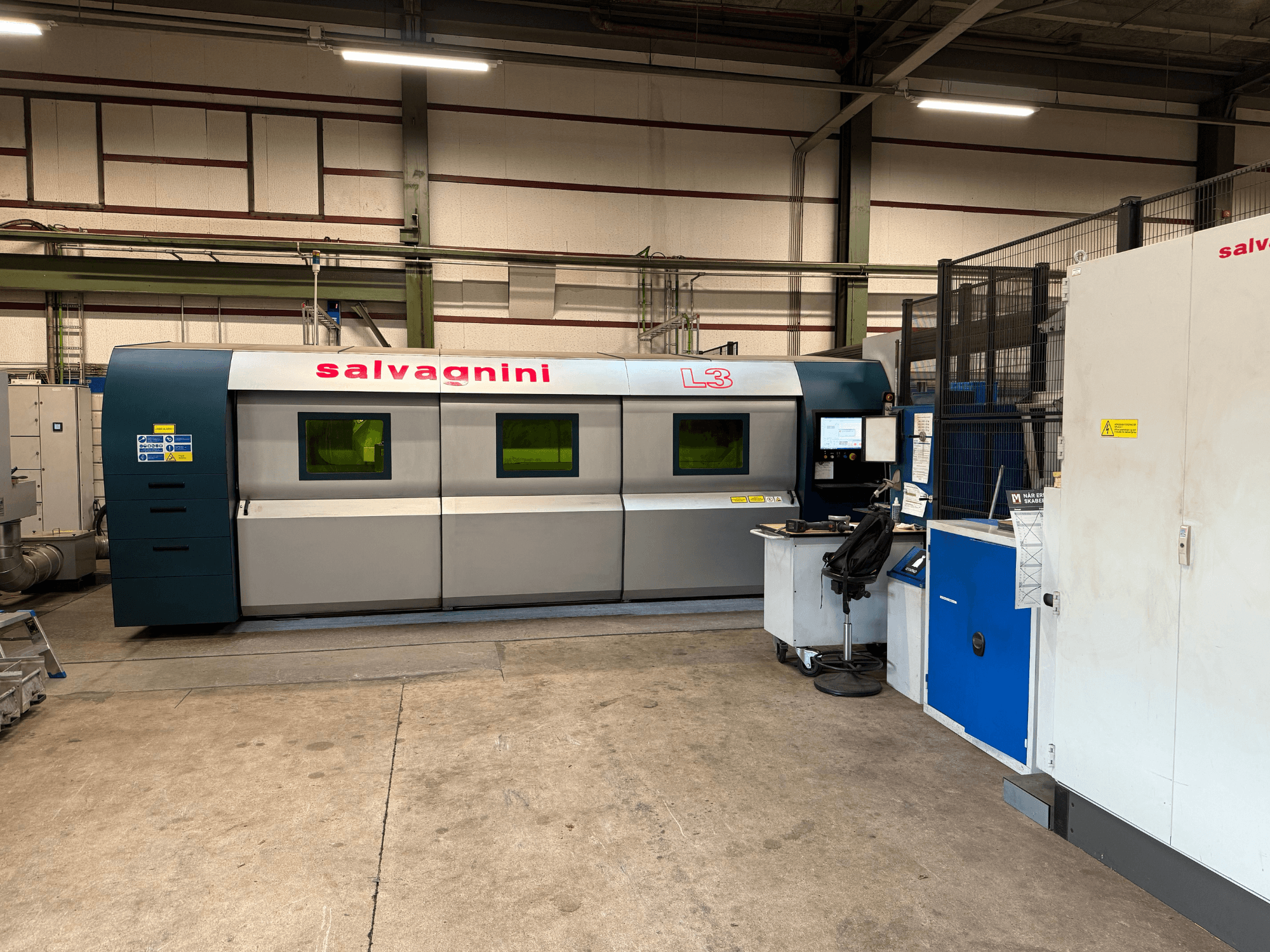 Salvagnini L3-4020 fiberlaserskärmaskin i fabriksinställning, framifrån, med kontrollpanel och hanteringssystem.