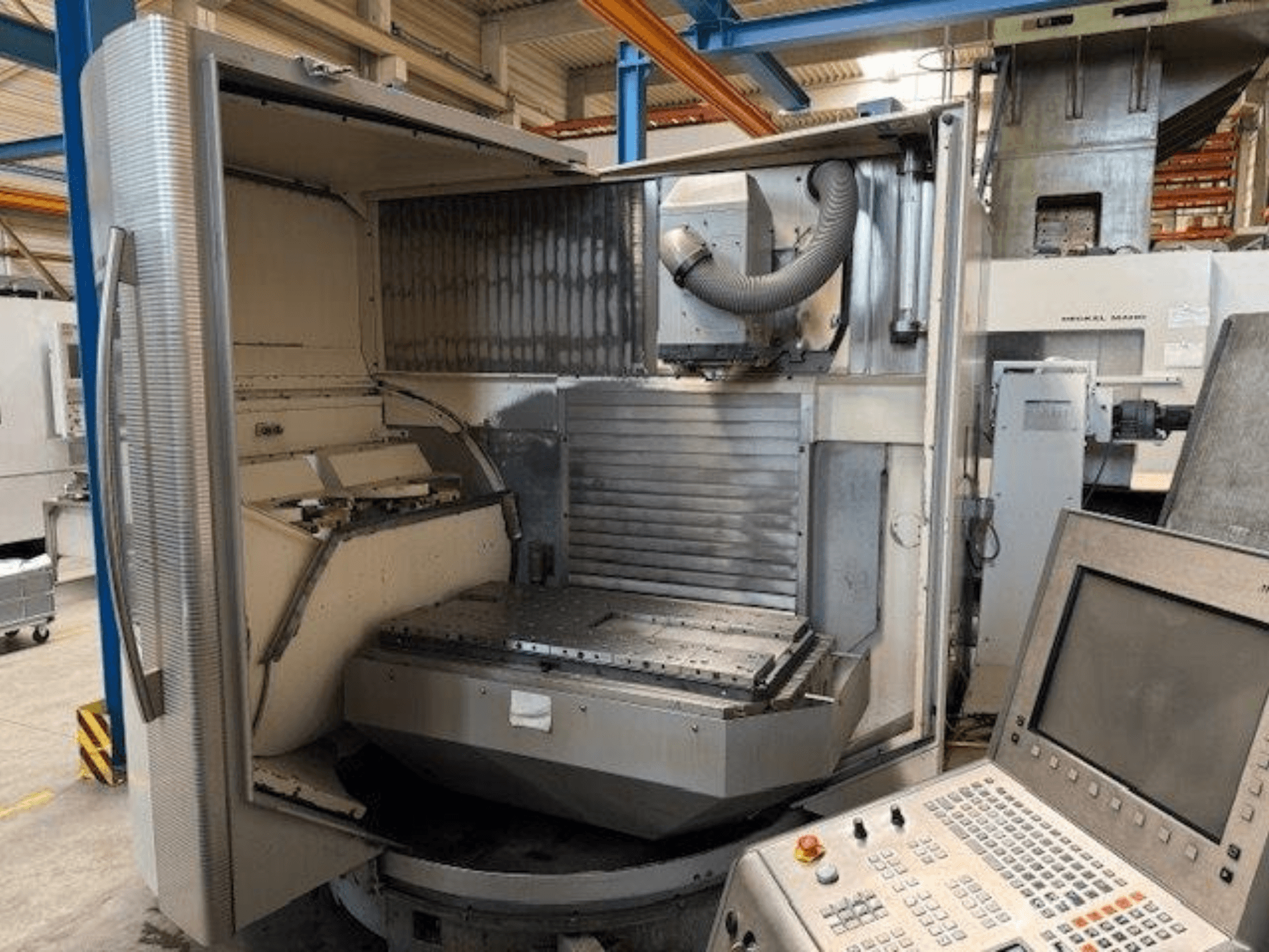 DMG MORI DMU 80T vertikalt bearbetningscenter, framifrån med öppet hölje och kontrollpanel.