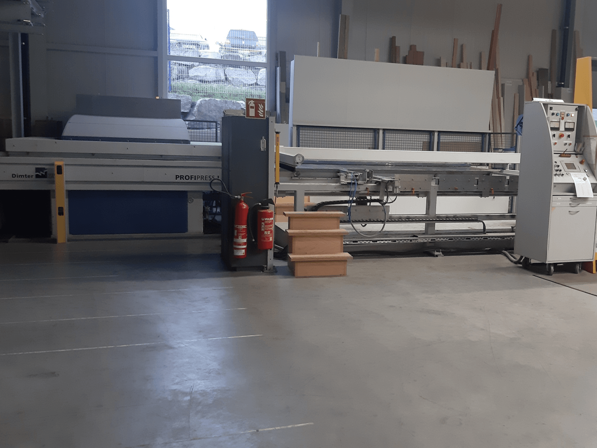 Dimter ProfiPress-maskin i en verkstad, sedd framifrån, med kontrollpanel och brandsläckare i närheten.