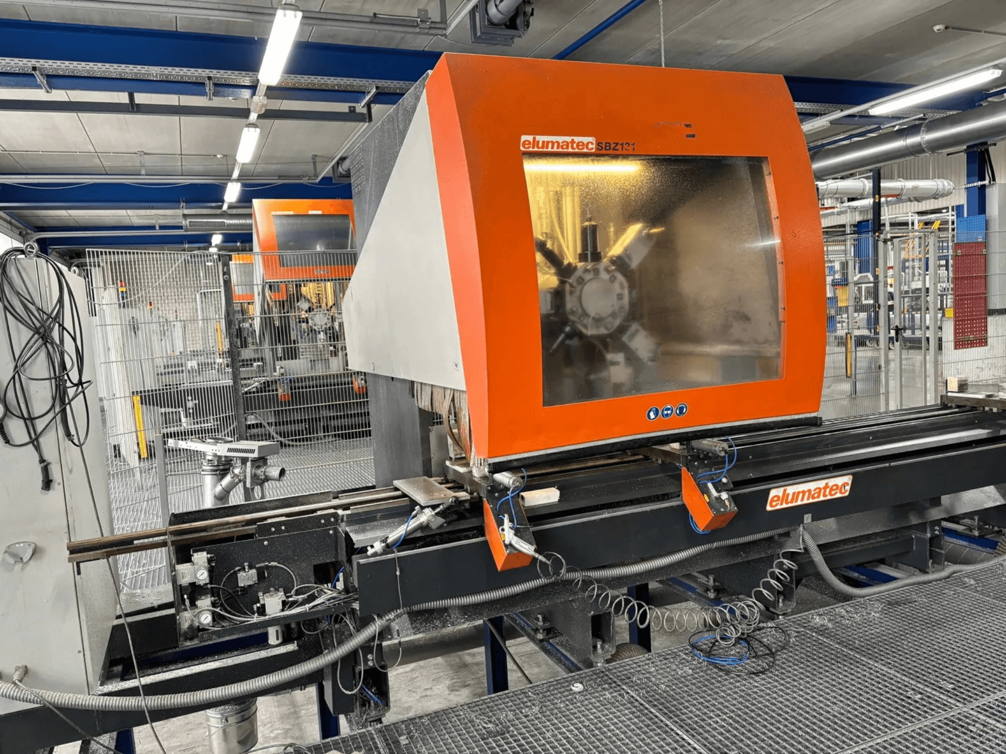 Elumatec SBZ 131 vertikal fleroperationsmaskin, framifrån, visar kontrollpanel, maskindetaljer och omgivande arbetsmiljö.