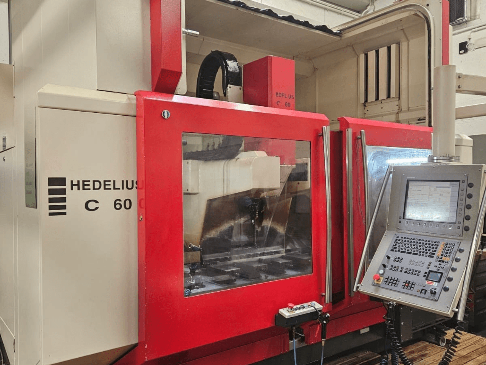 HEDELIUS C60 vertikal fleroperationsmaskin från sidan, med röd frontpanel och styrkonsol med display.