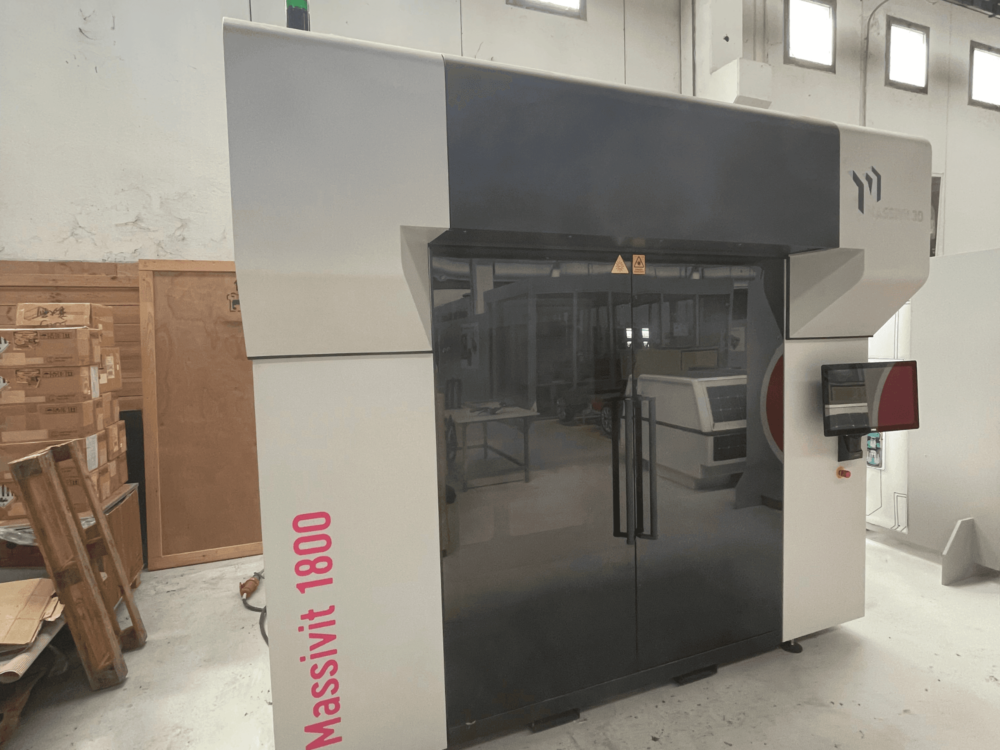 MASSIVIT Massivit 1800 – en 3D-skrivare för plast, visad i sidovy, med pekskärm och en elegant design i svart och vitt.