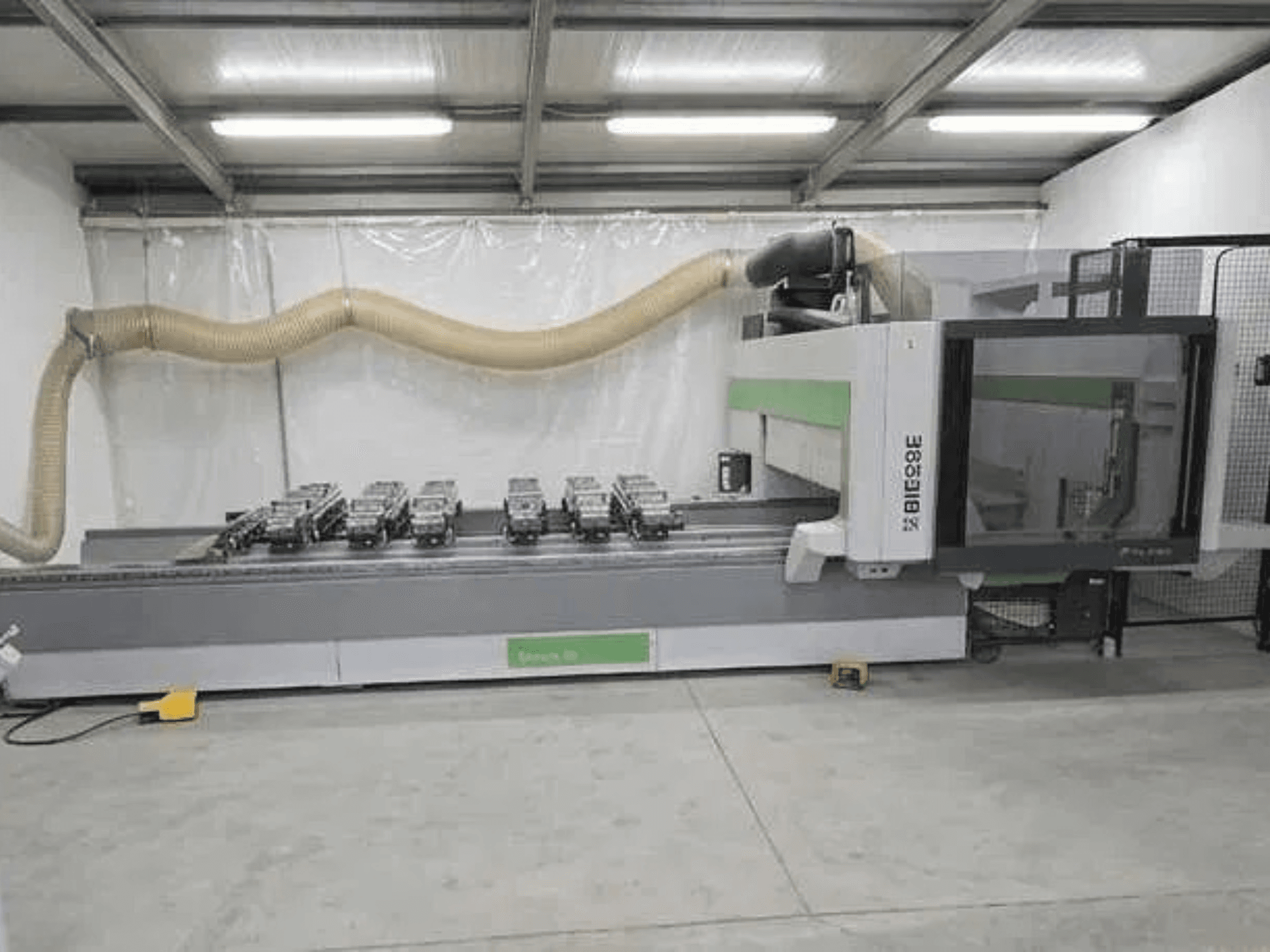 BIESSE Rover K1232 CNC-bearbetningscenter sett från sidan, där vakuumsugkopparna och dammutsugssystemet syns.