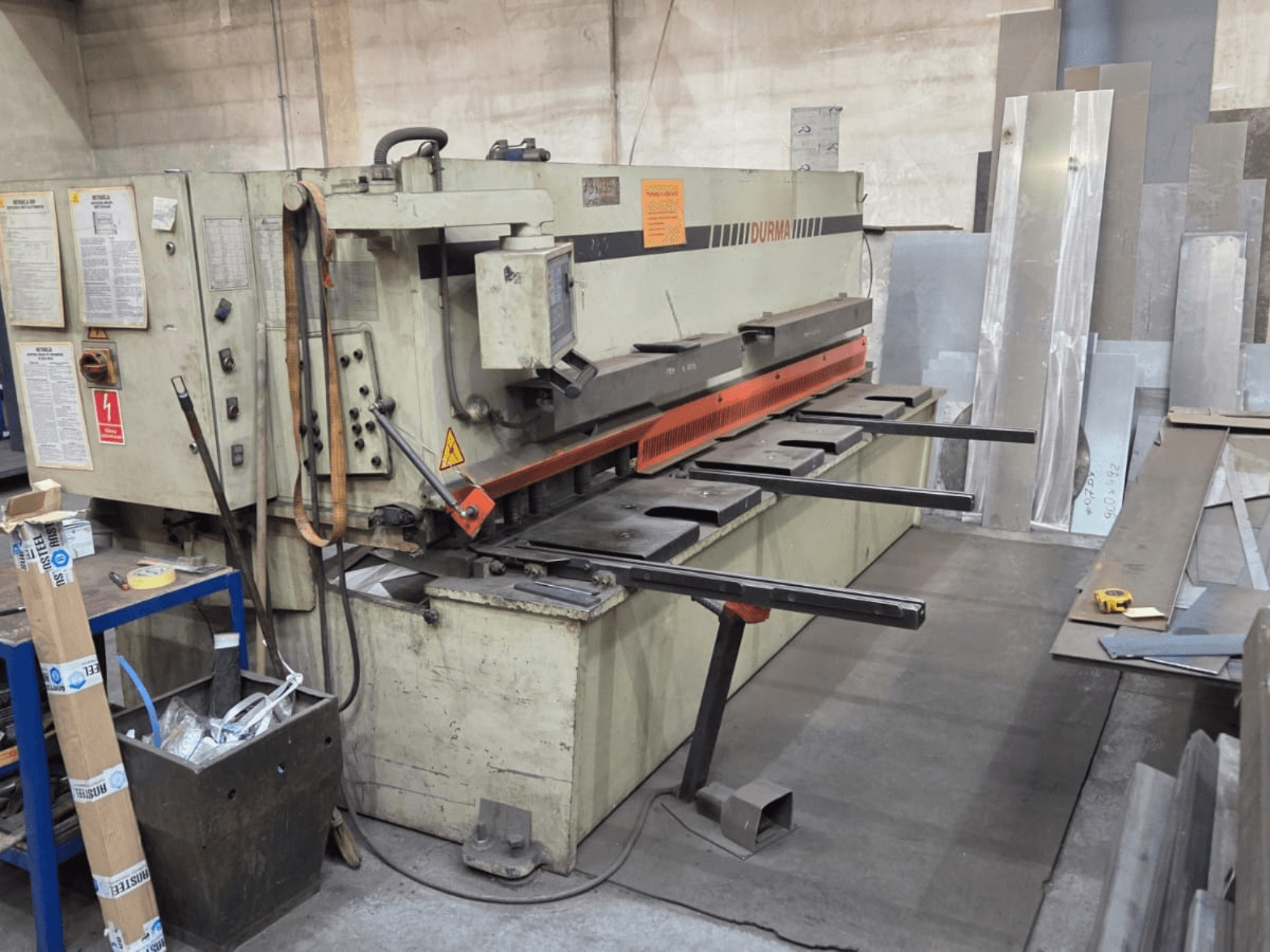 Hydraulisk skärmaskin Durma SB 3060, framifrån, visar reglage, skärblad och metallplåtar i arbetsutrymmet.