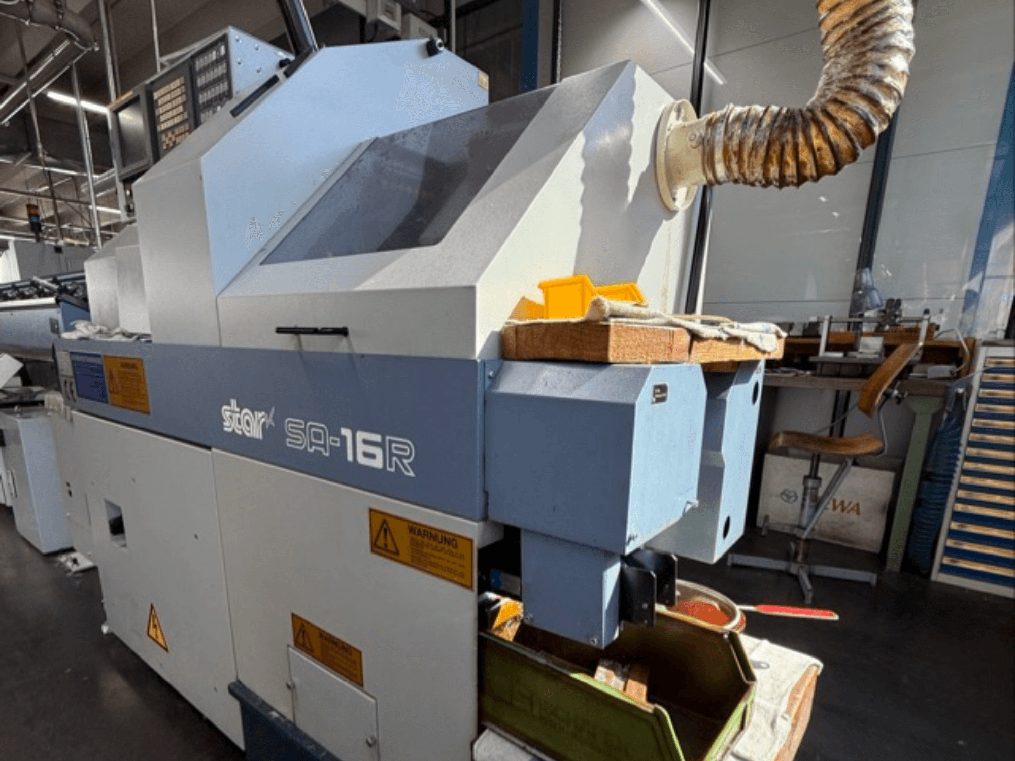 Stark SA-16R-maskinen sedd framifrån, med avsmalnande utblås och arbetsyta med gula verktyg och varningsetiketter.