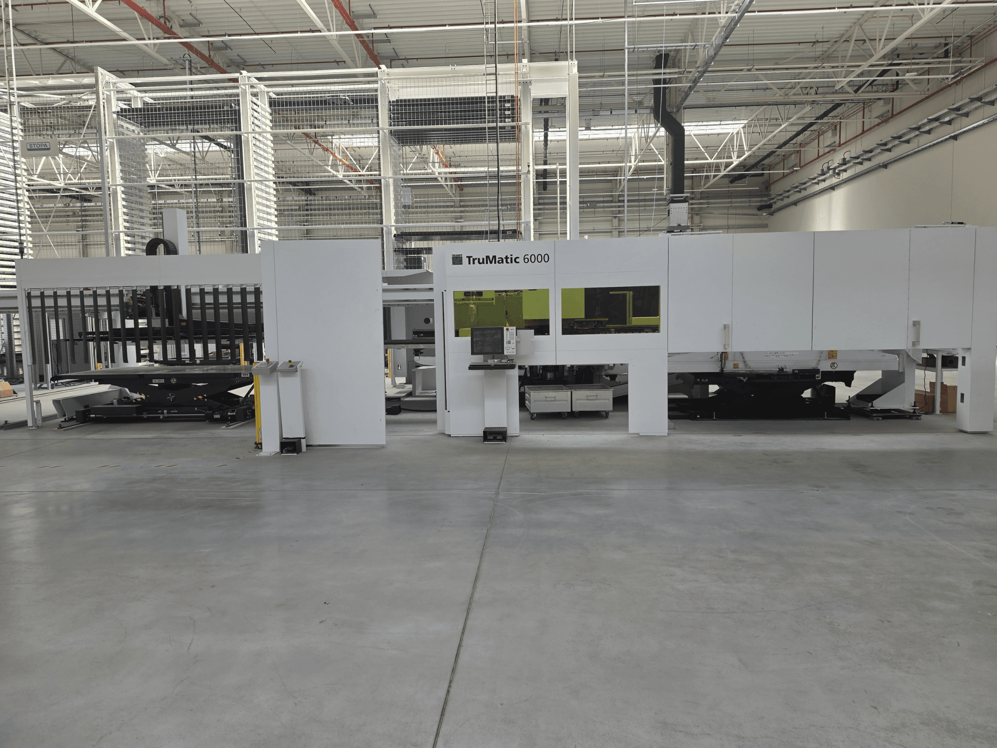 TRUMPF TruMatic 6000 – automatiserat produktionssystem för plåtbearbetning, framifrån sett, med kontrollpanel och lastningsområde.