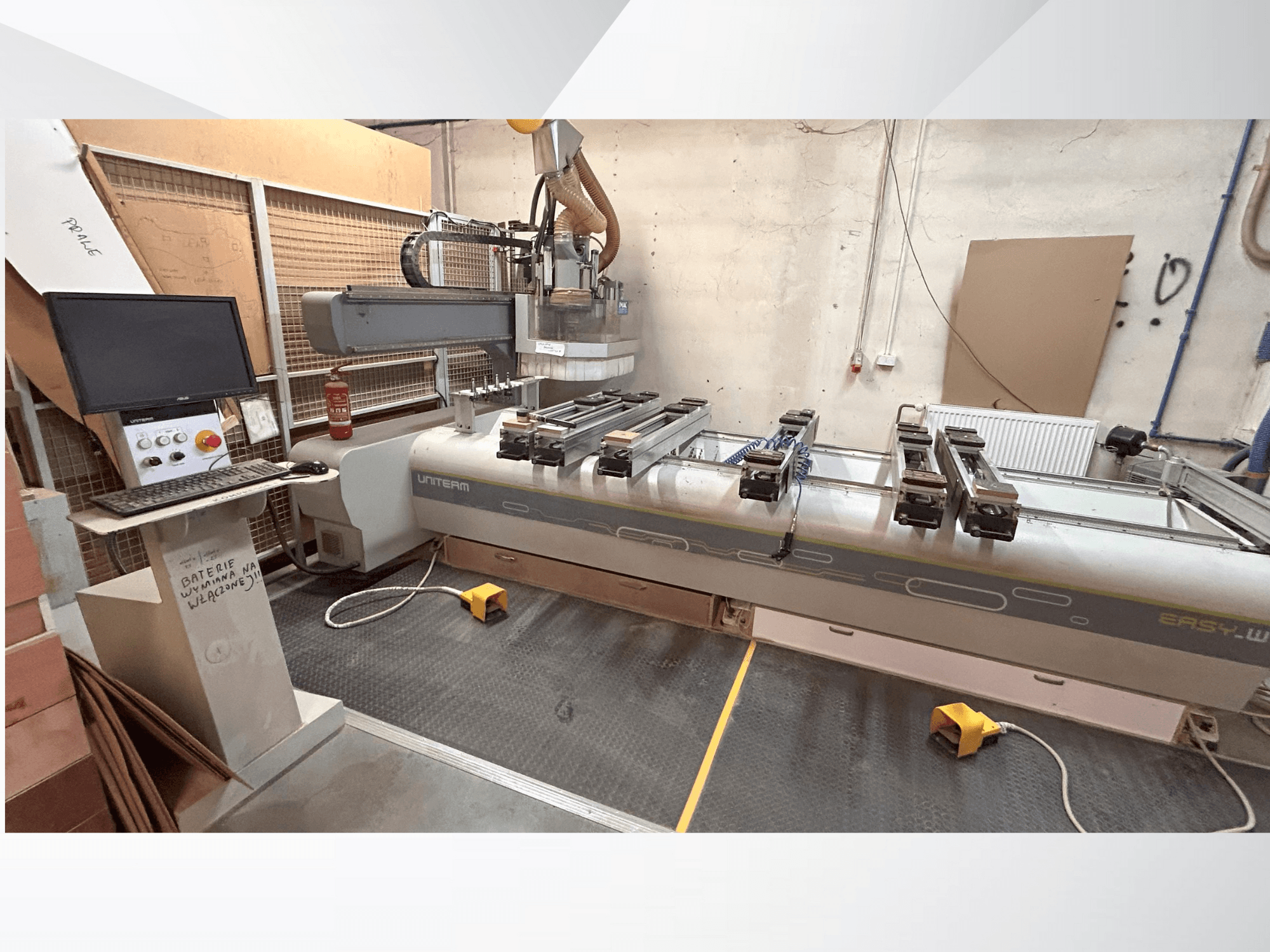 Frontvy av en UNITEM EASY-W CNC-maskin med kontrollpanel, bildskärm och fastspända arbetsstycken på arbetsbordet.