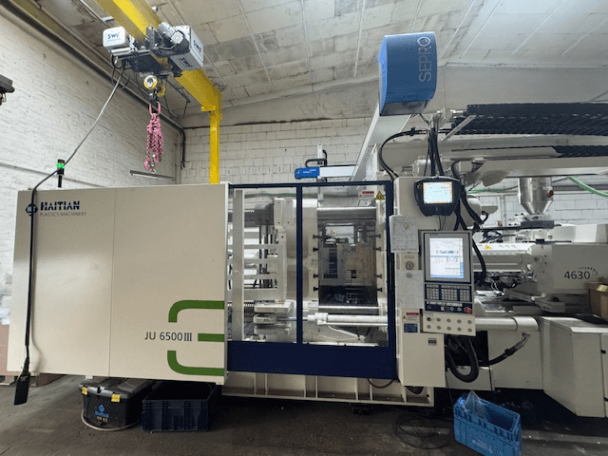 Haitisk Jupiter 3 JU 6500 hydraulisk formsprutningsmaskin, sidovy som visar kontrollpanel och maskindetaljer.