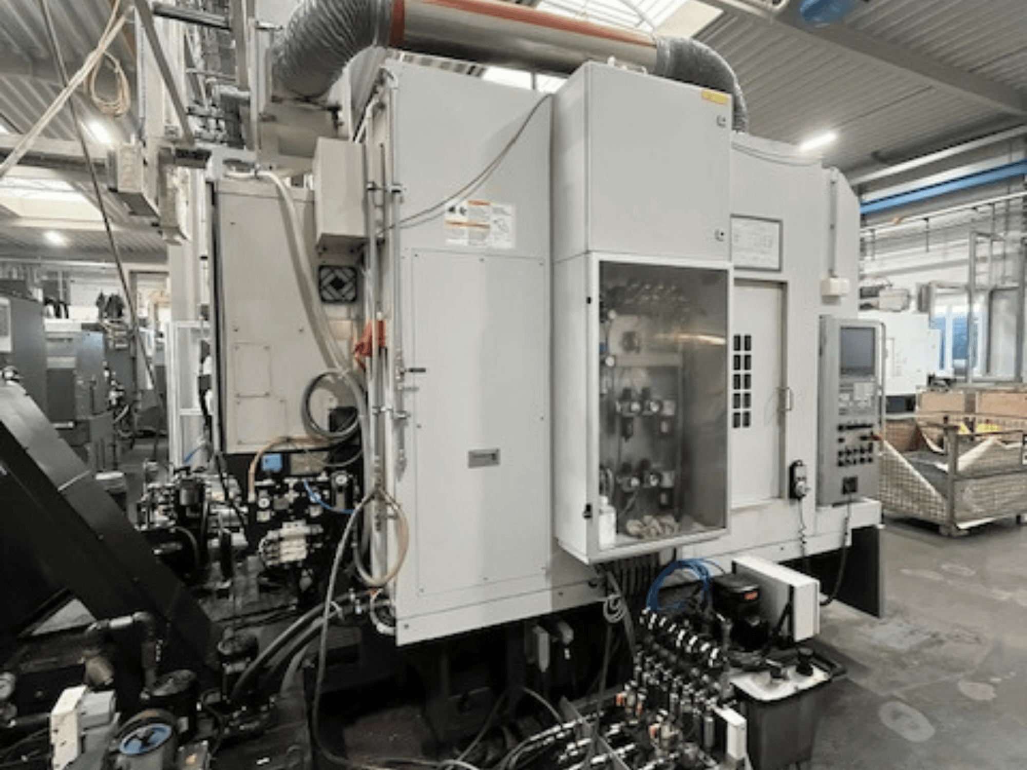 Industrimaskin i sidovy med kontrollpanel och hydrauliska komponenter, som visar märkes- och modelldetaljer.