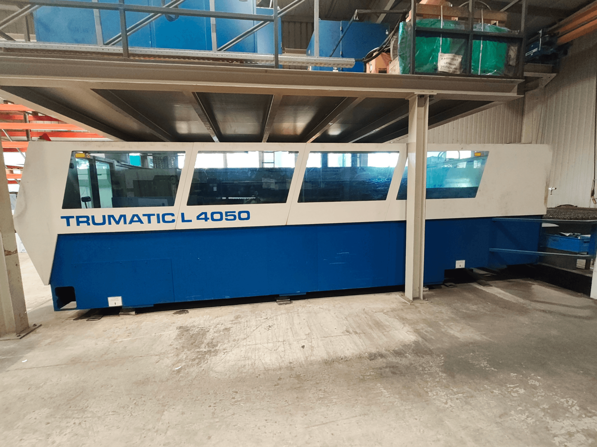 CO₂-laserskärmaskin TRUMPF TruLaser 450 sett från sidan, i blått och vitt, med synlig kontrollpanel och arbetsyta.