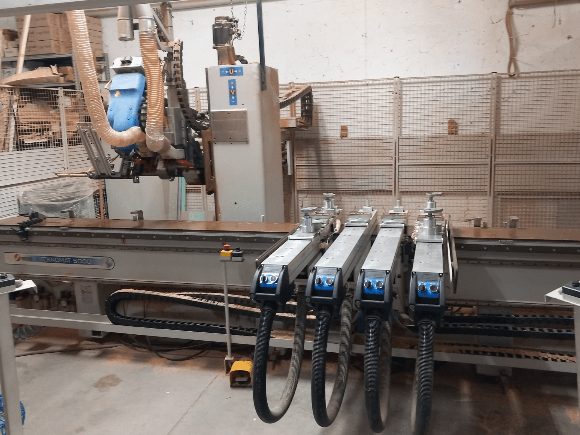 CNC-bearbetningscenter för trä MASTERWOOD TEKNOMAT 5000, framifrån med verktygshuvudet och flera sugslangar.