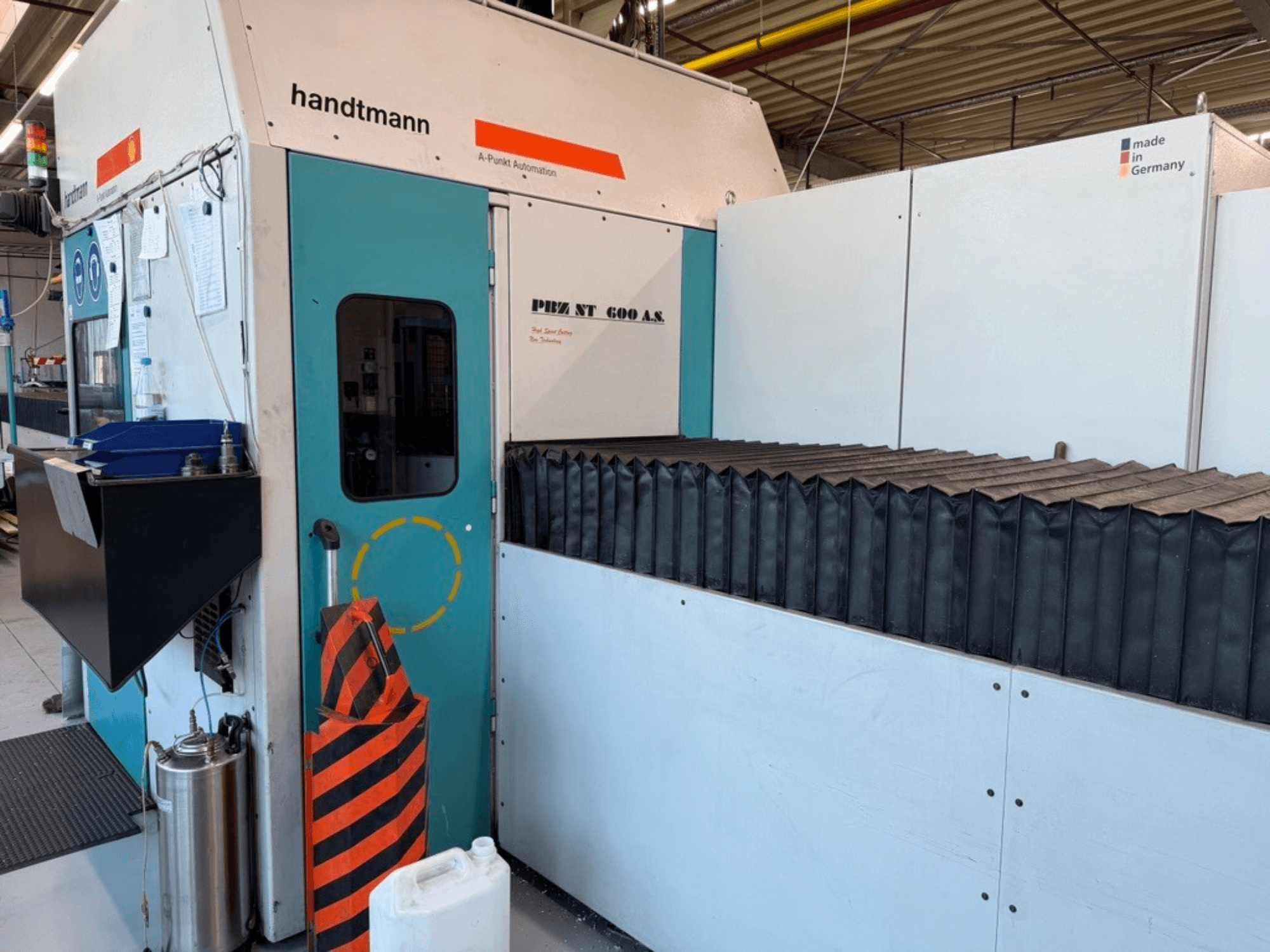 Frontvy av Handtmann PBZ NT 600 AS portalfräsmaskin med mörk arbetsyta och säkerhetsbarriärer.