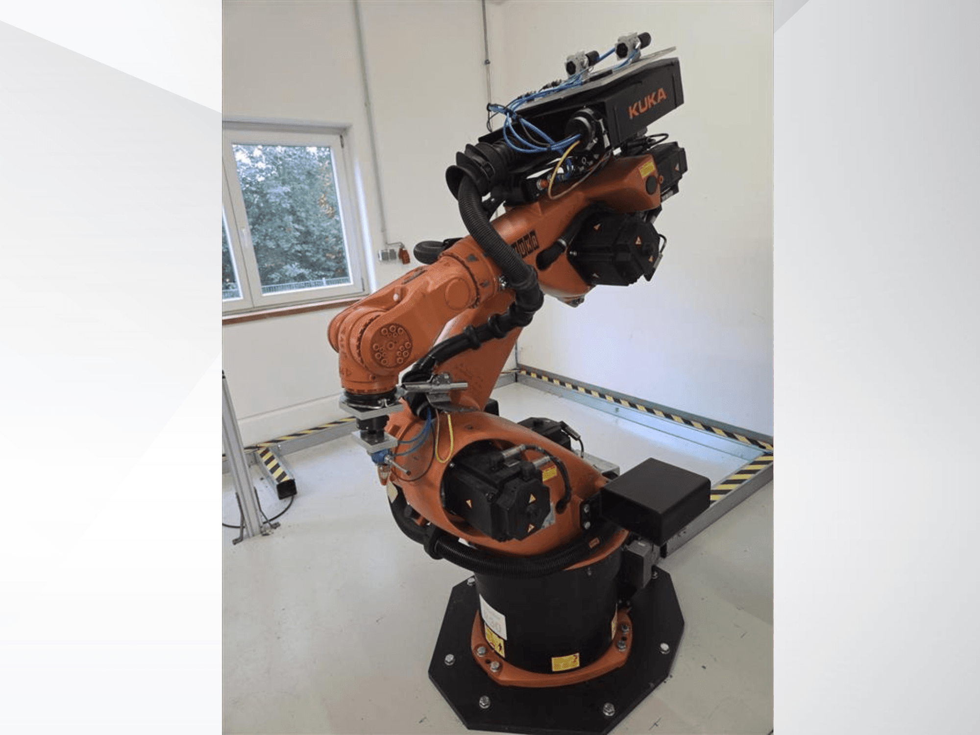 Robotarmen KUKA KR60 HA i sidovy, där de mekaniska lederna och kabeldragningen på en industriell bas syns tydligt.
