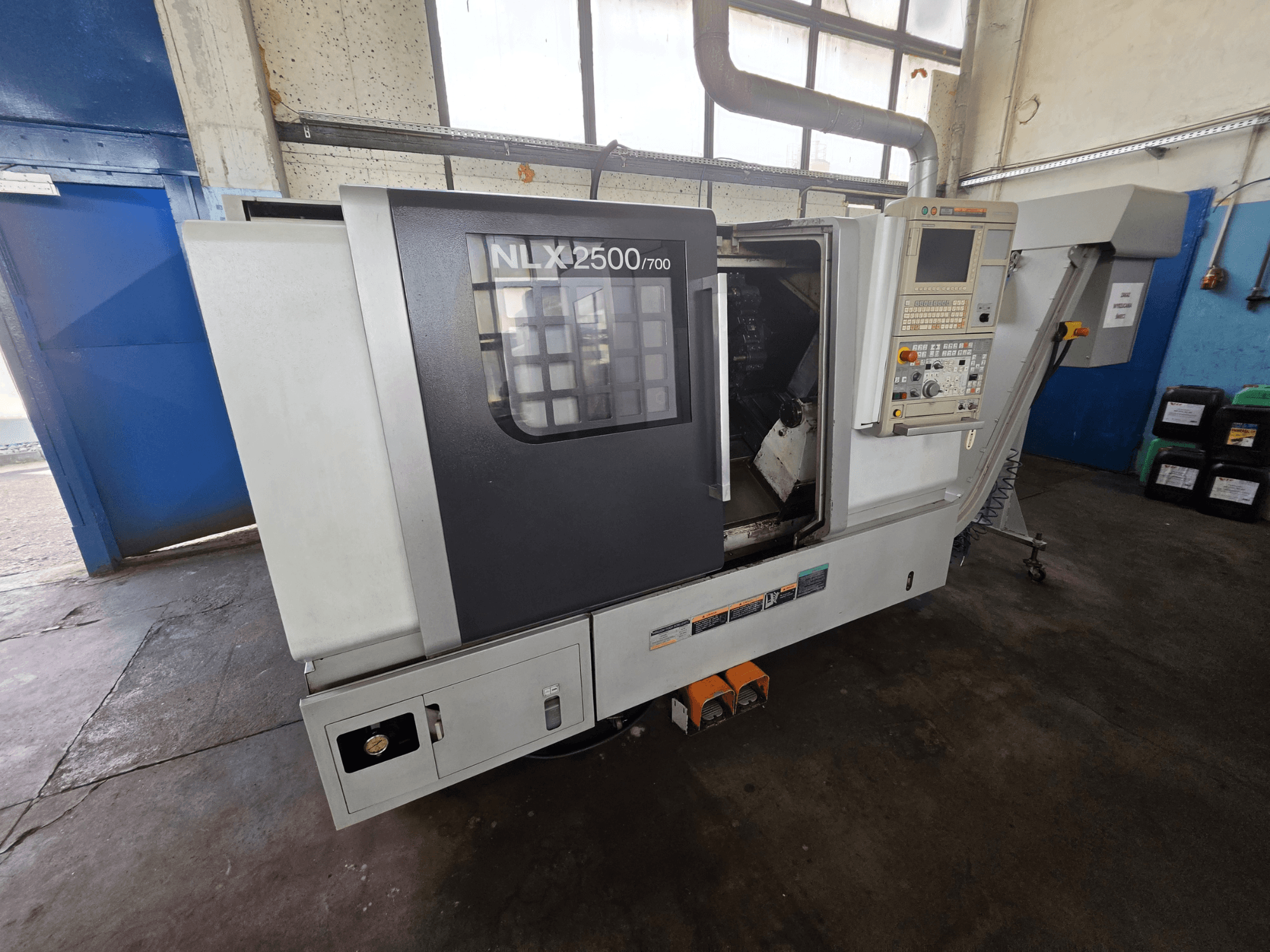 DMG MORI NLX 2500/700 horisontell svarv i sidovy, med kontrollpanel och synligt bearbetningsområde.