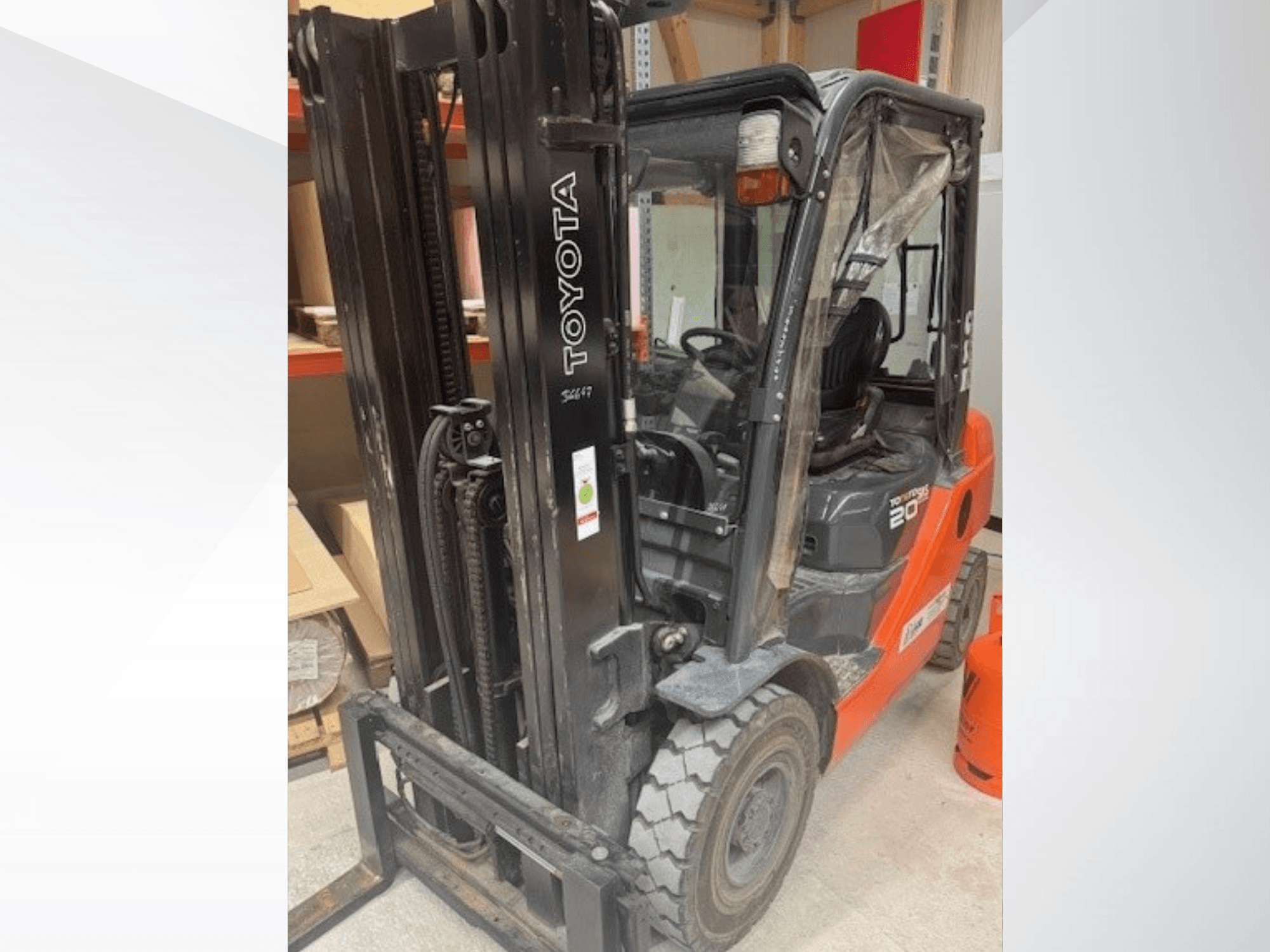 Toyota 20 gaffeltruck sedd framifrån, med svart mast, genomskinlig hytt och orange propantank bredvid.