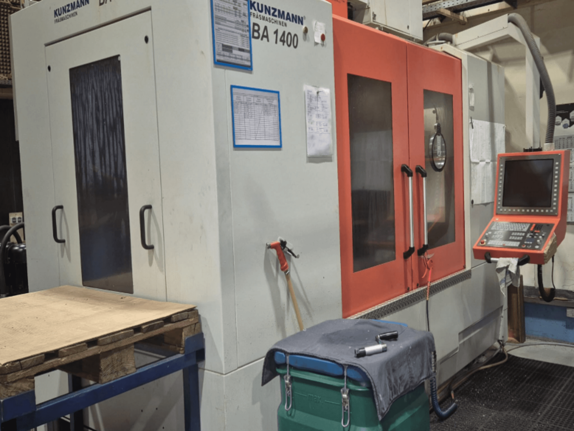 KUNZMANN BA1400 Vertikal fleroperationsmaskin framifrån, med orange dörrar, kontrollpanel och arbetsbord.