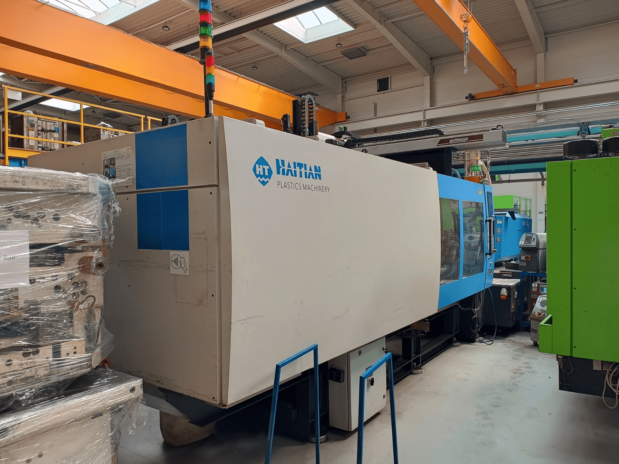 HAITIAN MARS 5300/4500 hydraulisk formsprutningsmaskin, sidovy, har blå och vit design, driftzoner och kontrollpanel.