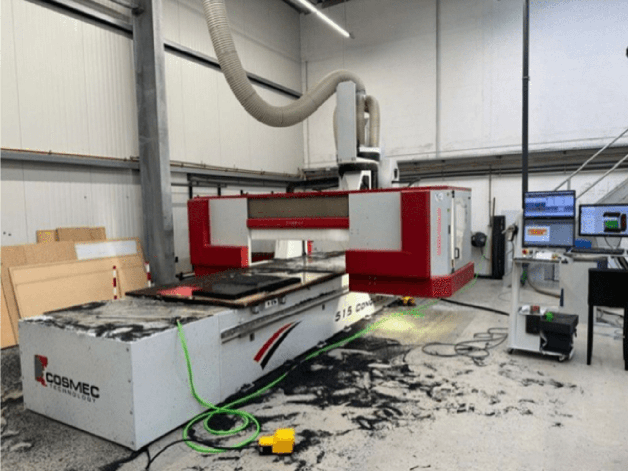 Cosmec 515 CNC-maskin i verkstad med en datorterminal, som visar en vy framifrån och damm utspridda på ytan.