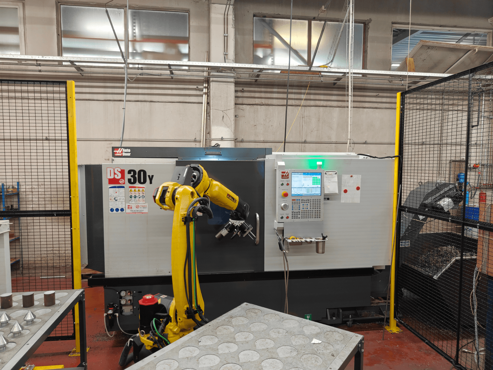 HAAS DS30Y horisontell svarv med robotarm, framifrån, där kontrollpanelen och arbetsområdet syns.