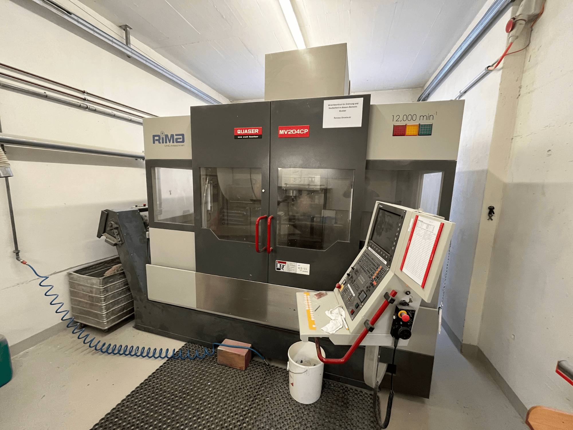 Quaser MV-204 CP vertikal fleroperationsmaskin framifrån, med kontrollpanel och driftsdetaljer.