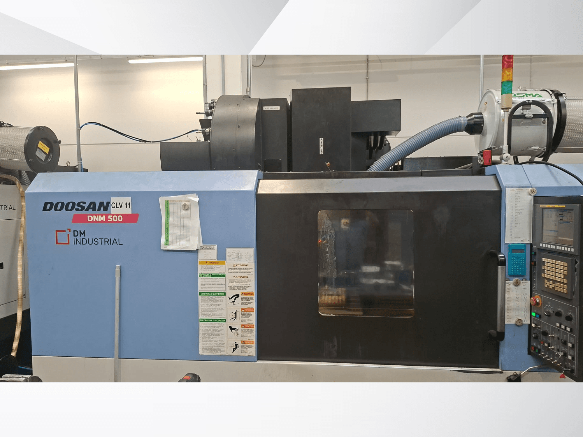 DOOSAN DNM 500 vertikalt bearbetningscenter sett från sidan, med kontrollpanel och driftskomponenter.