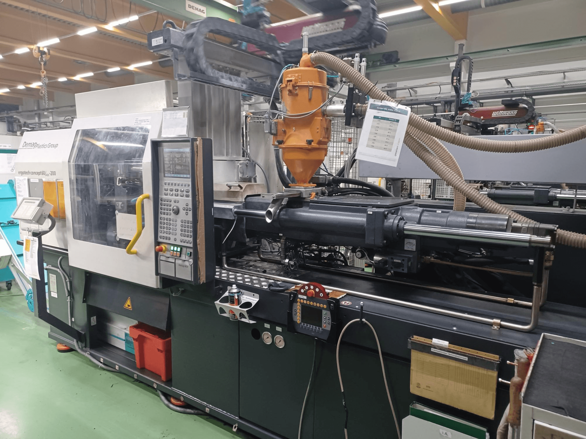 Demag Ergotech 200 formsprutningsmaskin, framifrån, med kontrollpanel, munstycke och driftskomponenter synliga.