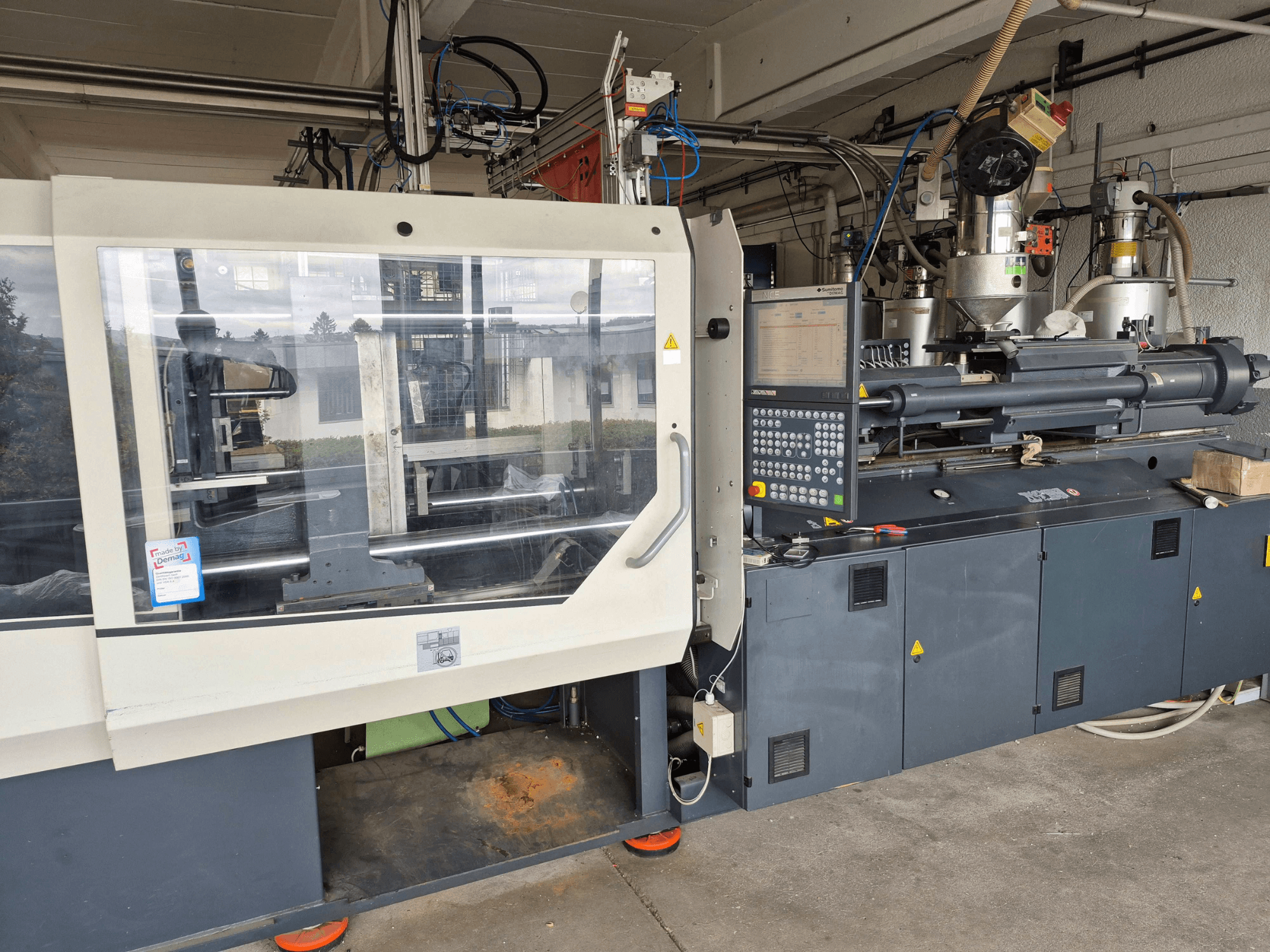 Hydraulisk formsprutningsmaskin, SUMITOMO SHI DEMAG Systec 210/580-1450, framifrån med kontrollpanel och synliga komponenter.