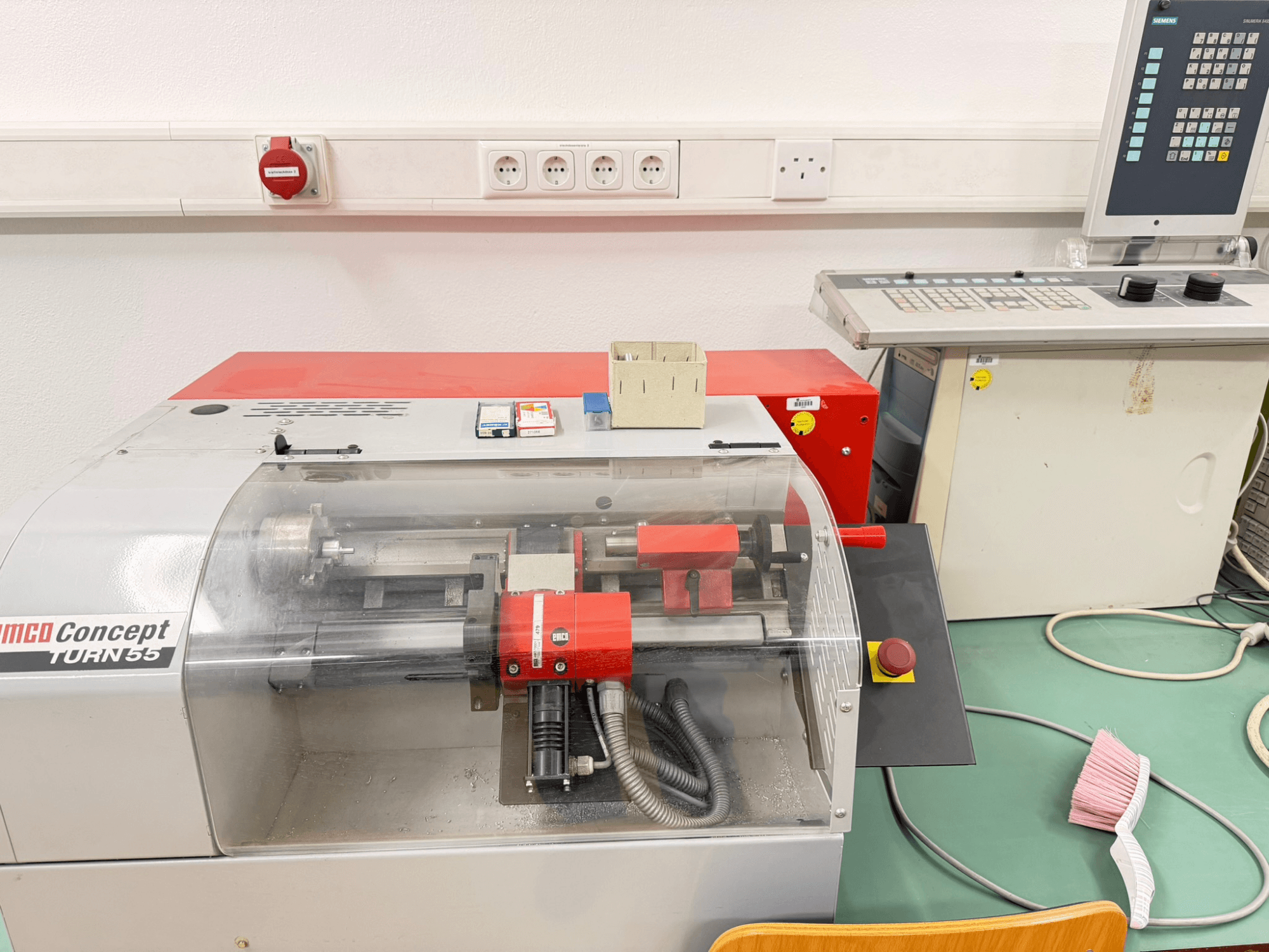 EMCO Concept Turn 55 horisontell svarv med röd och grå exteriör, frontvy som visar reglage och arbetsområde.