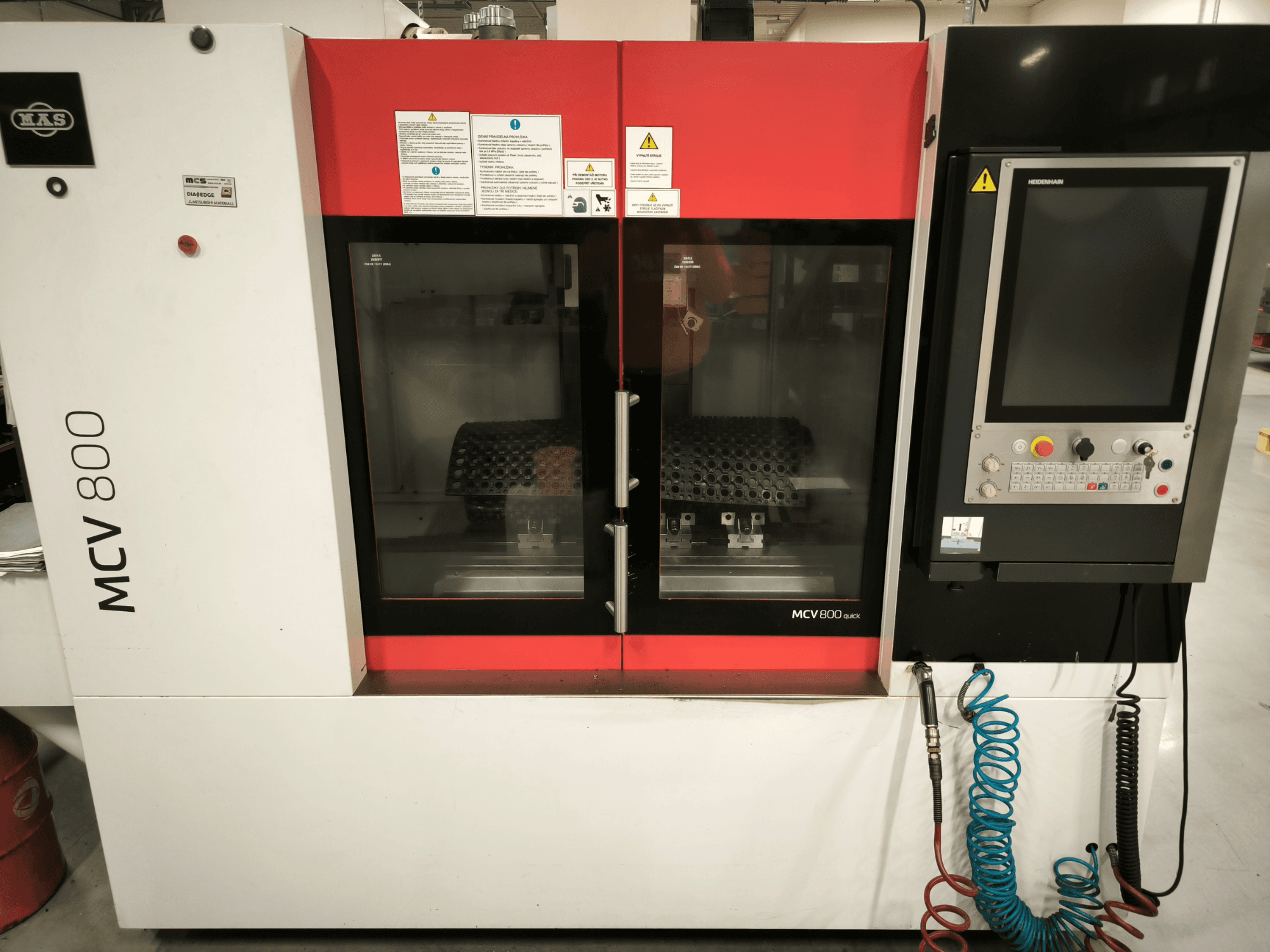 Vertikal bearbetningscenter KOVOSVIT MAS MCV 800 QUICK, framifrån med kontrollpanel och dubbla glasdörrar som visar arbetsutrymmet.