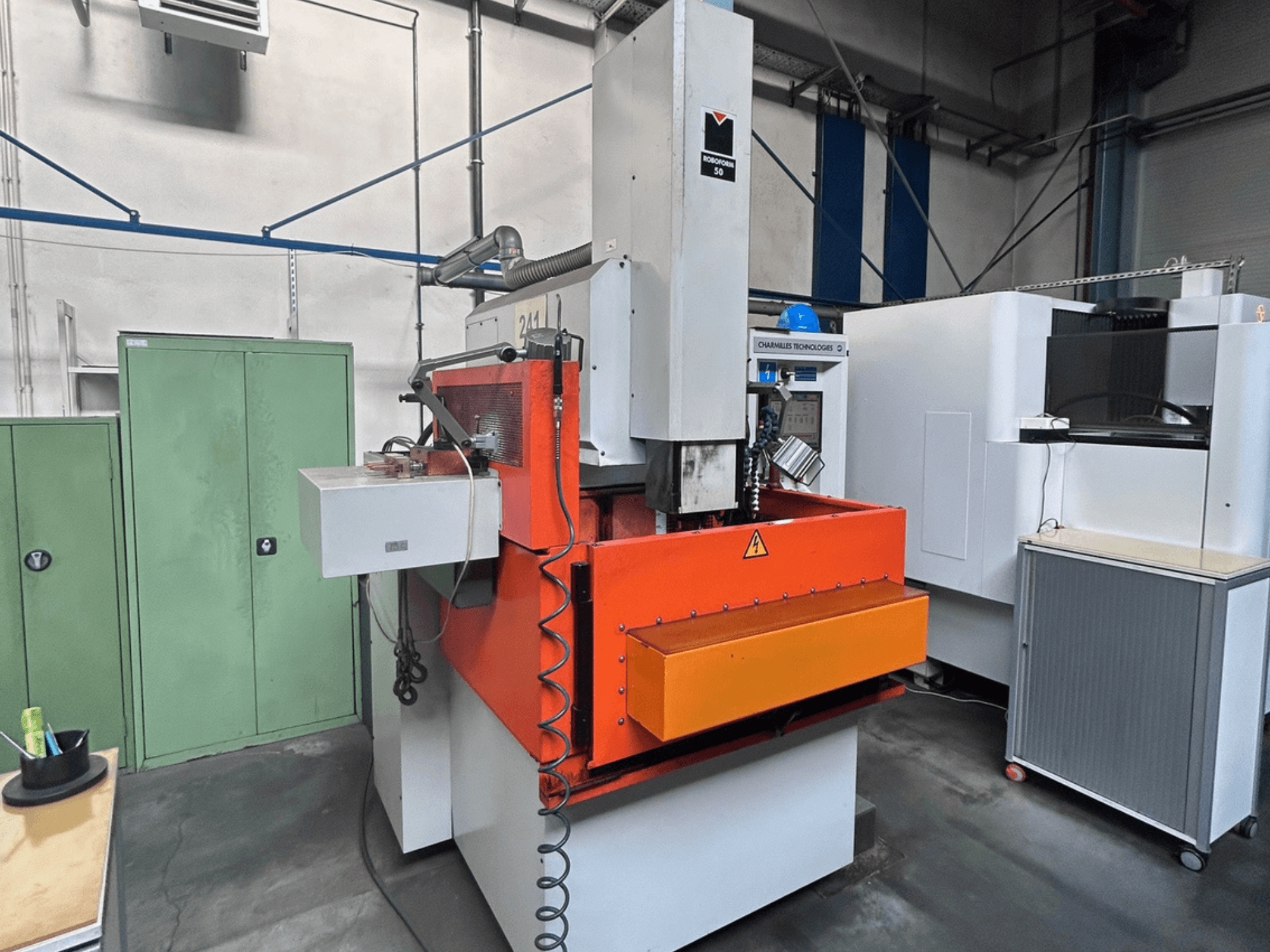 Framsida av CHARMILLES ROBOFORM 50 sänkgnistmaskin med orange panel, styrgränssnitt och kringutrustning.