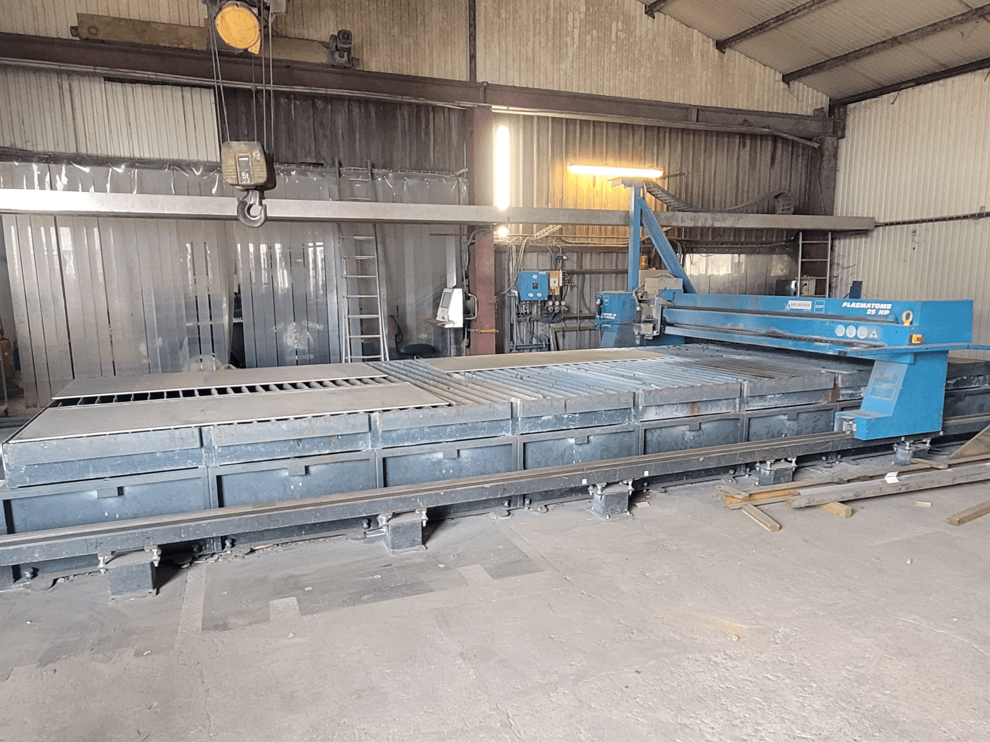 SAF Plasmatone 25Hp plasmaskärmaskin, vy från sidan, visar skärbädden och driftskomponenterna i en industriell miljö.