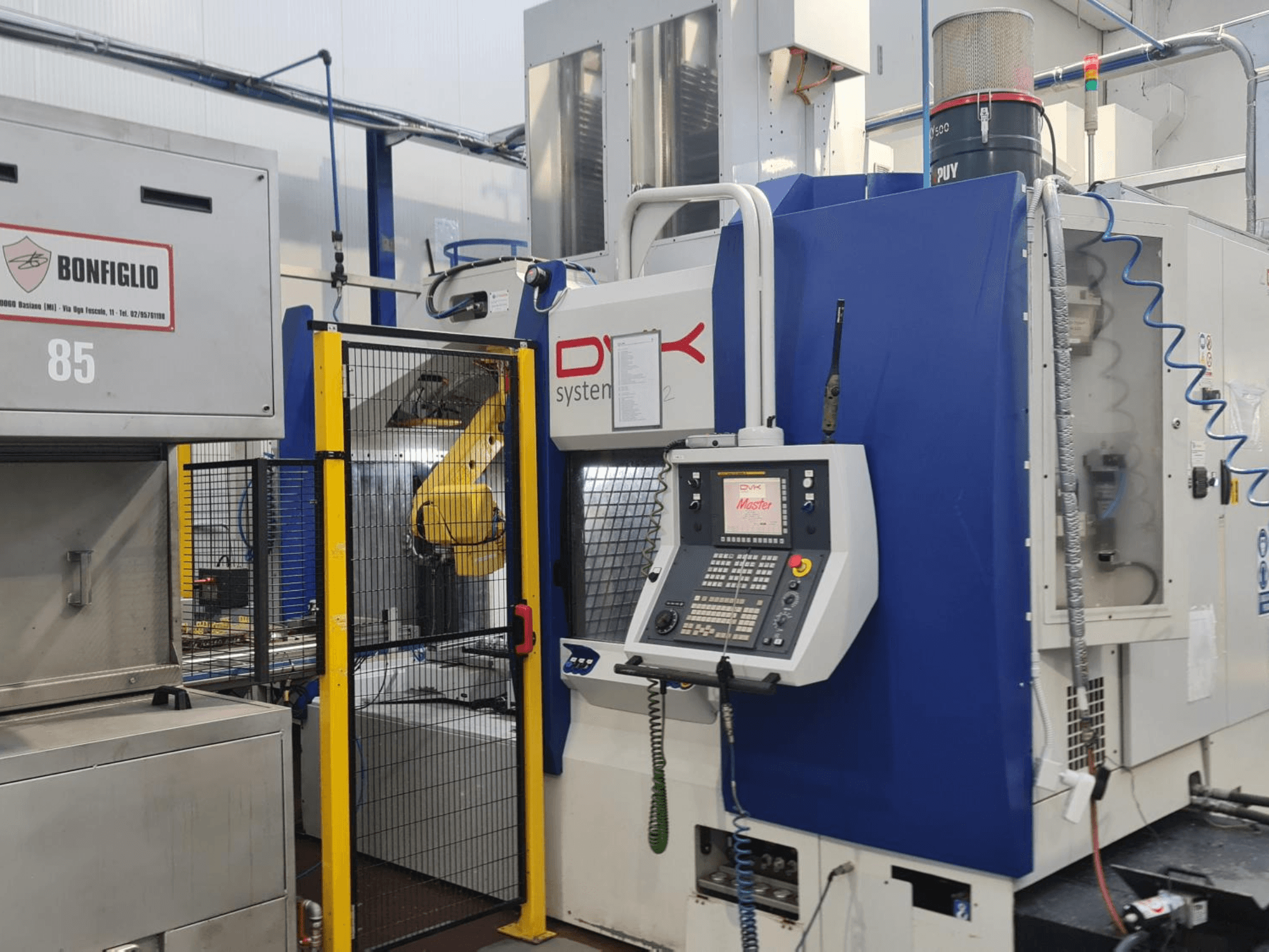 DVK System Master – horisontellt bearbetningscenter, framifrån sett, med kontrollpanel, säkerhetsgrind och robotarm.