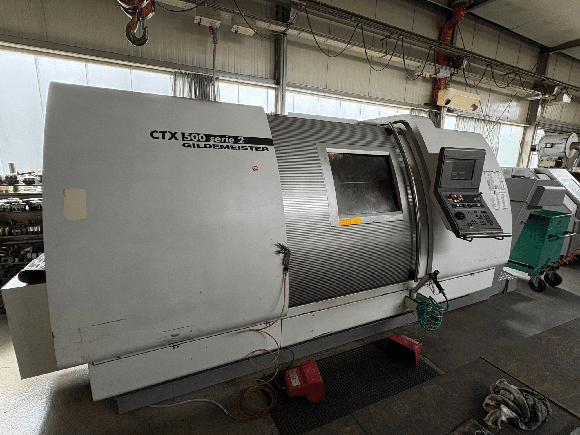 Gildemeister CTX 500 S2 horisontell svarv, sidovy som visar kontrollpanelen och detaljer på huvuddelen.