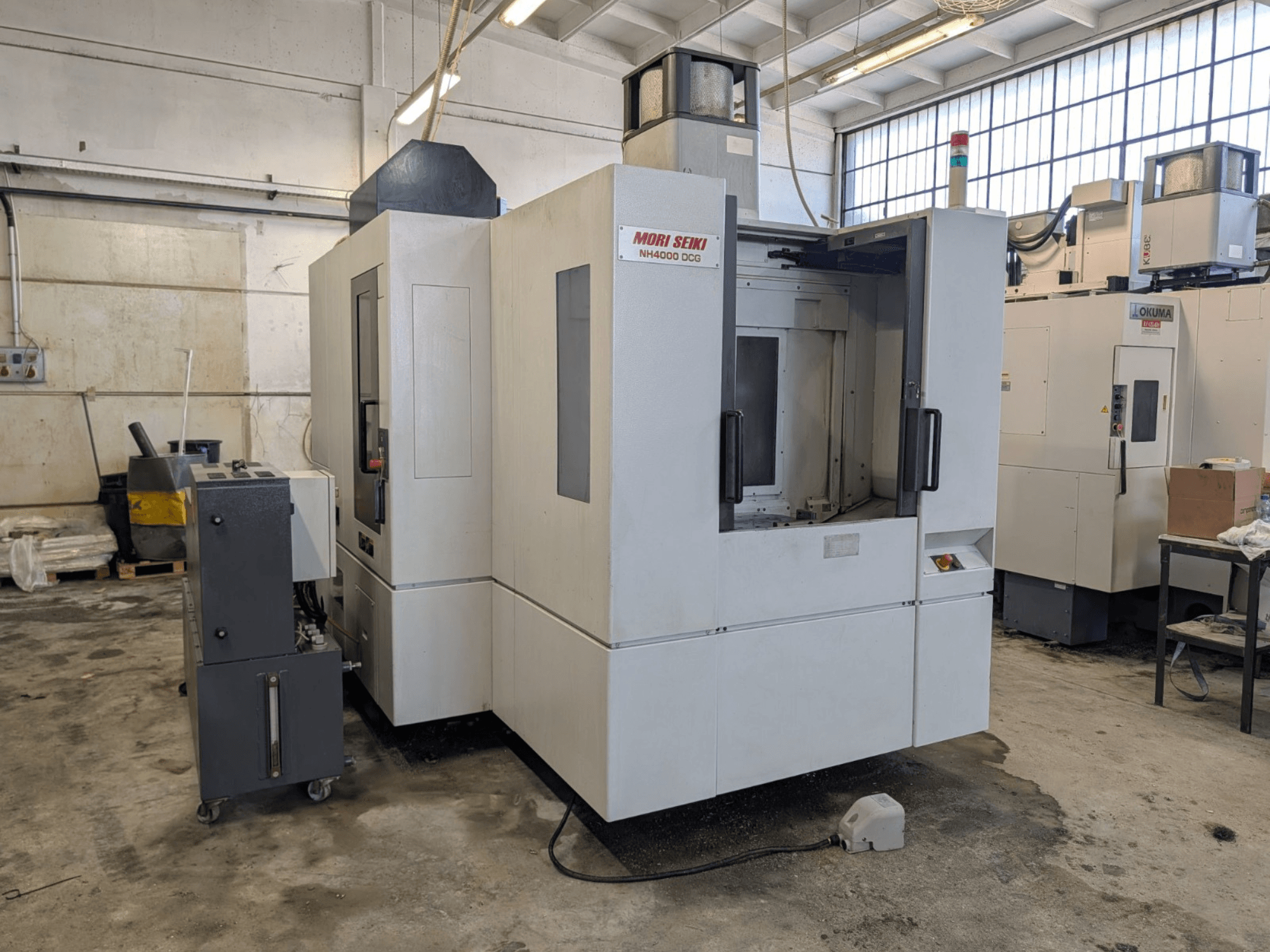MORI SEIKI NH 4000 DCG horisontell fleroperationsmaskin, framifrån, visar kontrollpanelen och arbetsområdet, grå och vit finish.