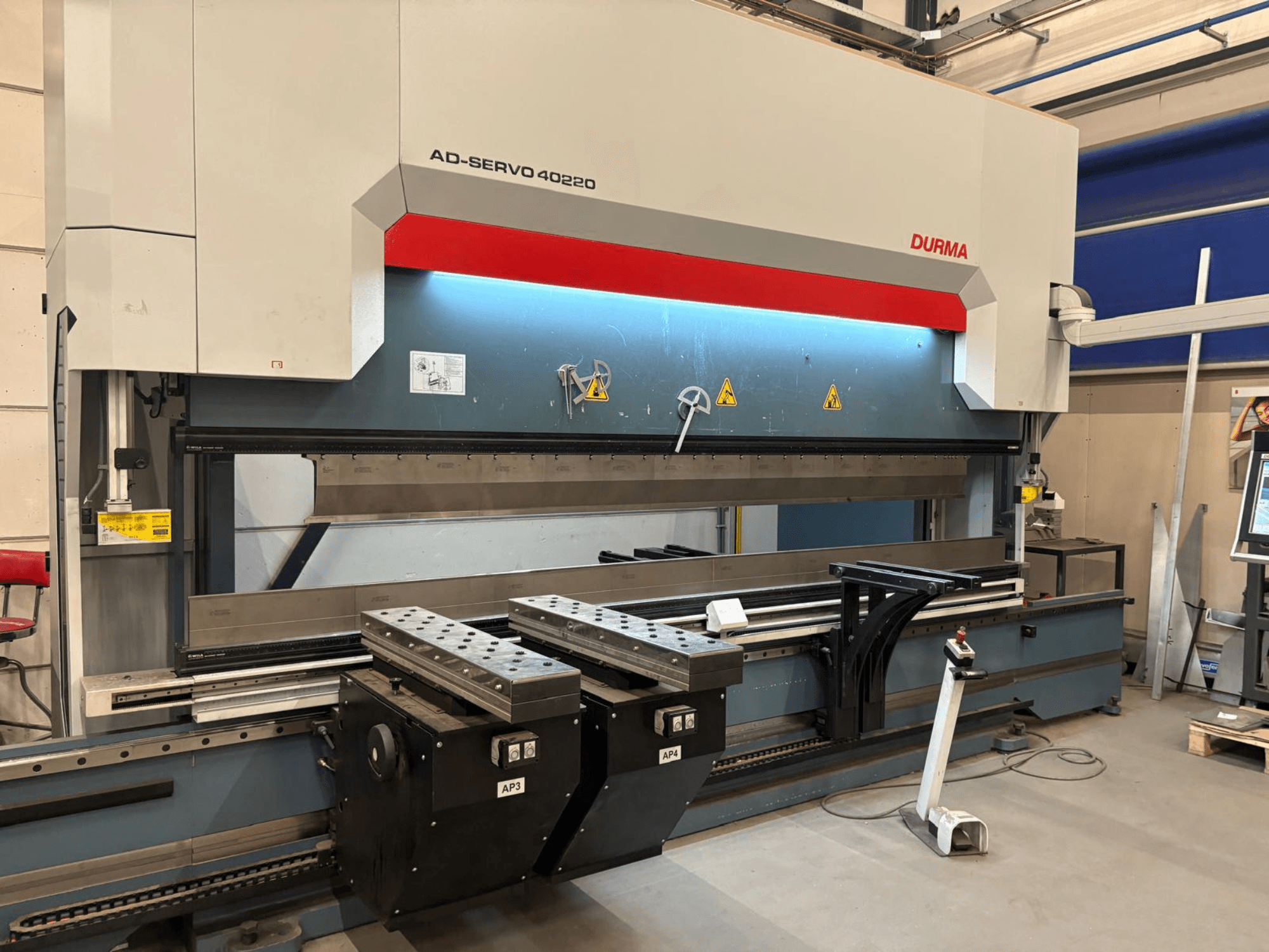 Durma AD-SERVO 40220 kantpress, framifrån, med kontrollpanelen, hydraulsystemet och verktygen på arbetsbordet.