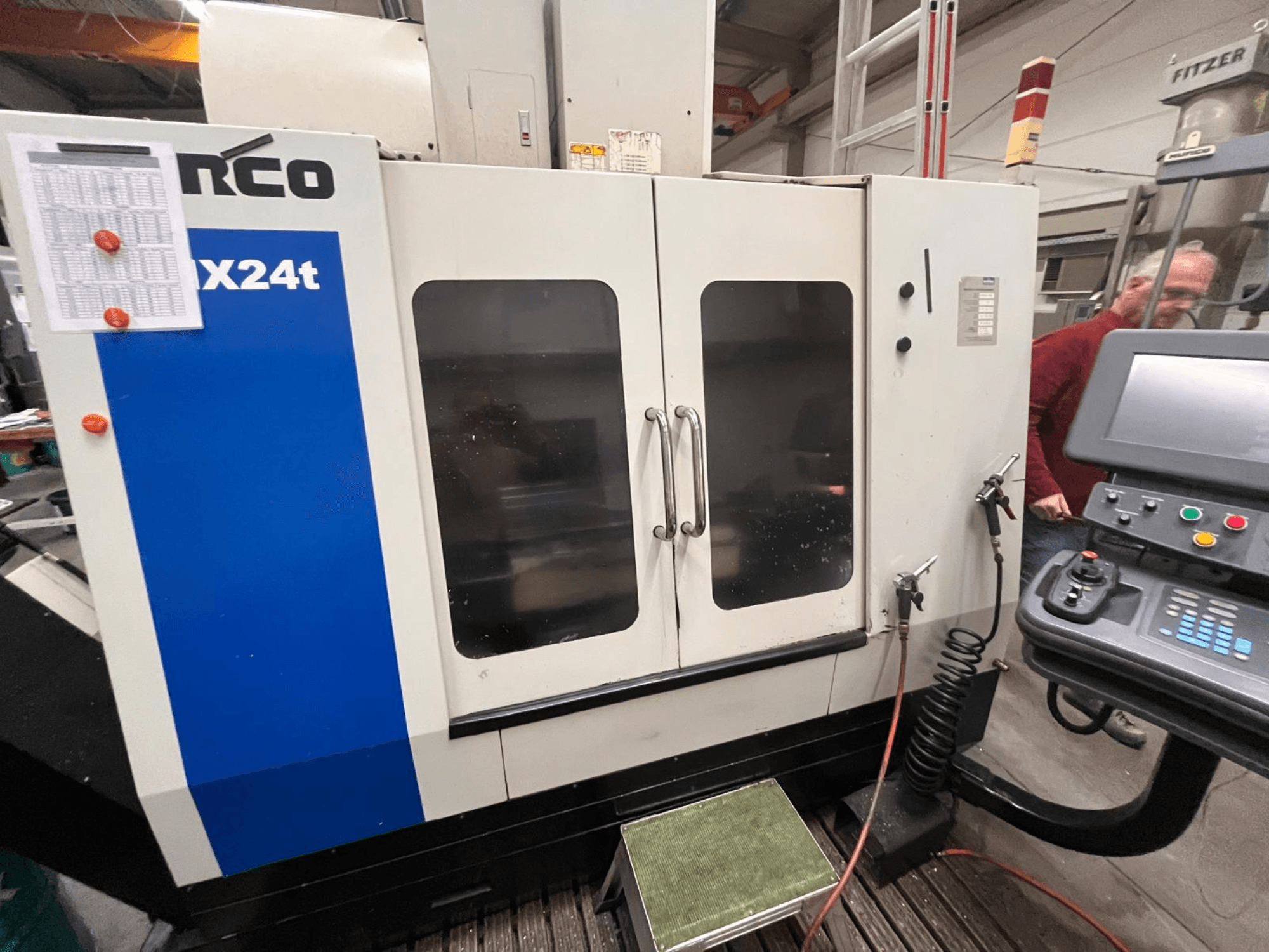 Vertikal fleroperationsmaskin från Hurco, modell VX24t, visad framifrån med kontrollpanel och transparenta dörrar.