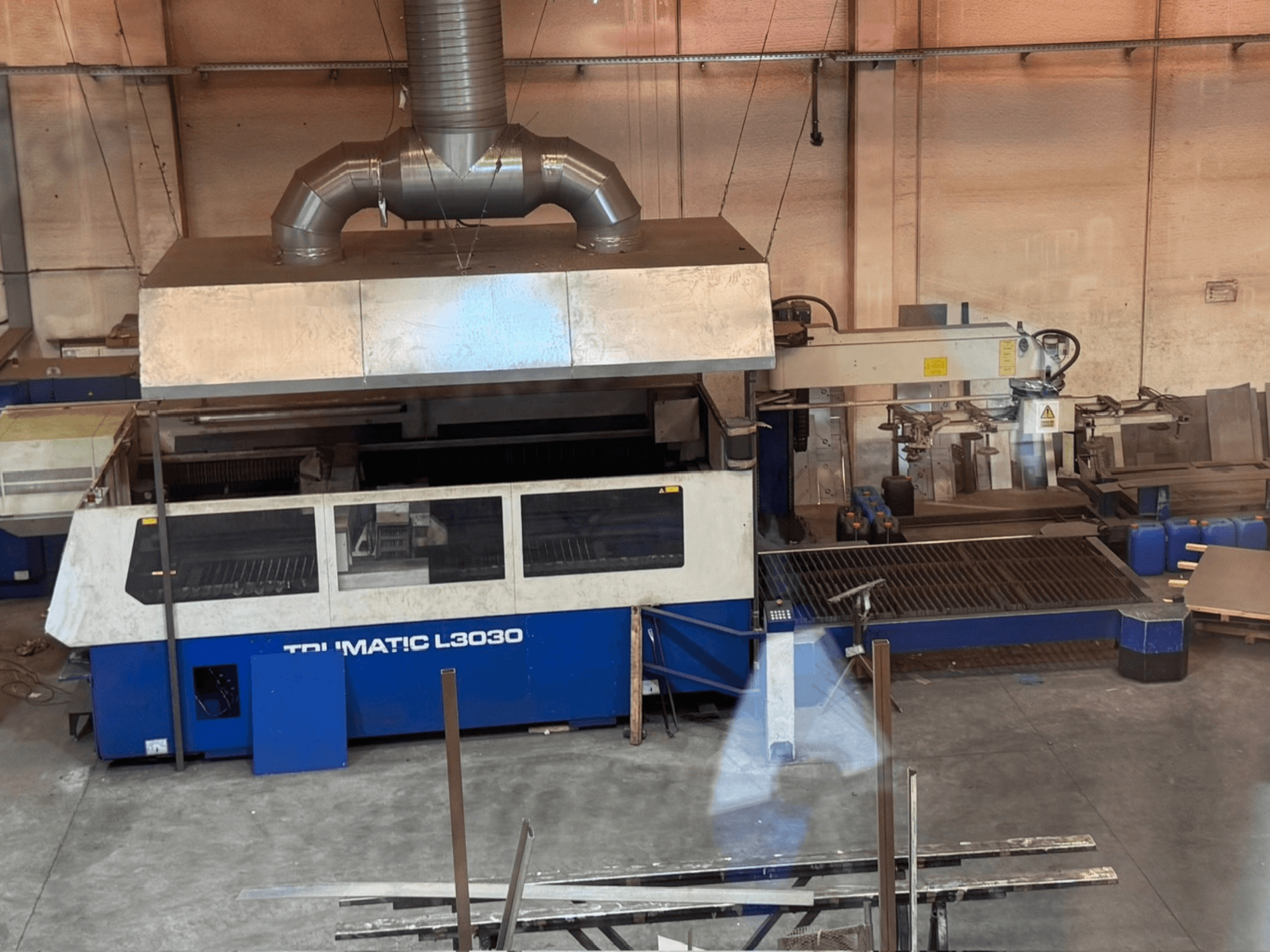 CO2-laserskärmaskin TRUMPF TRUMATIC L3030 i en verkstad, framifrån med kontrollpanelen och skärbordet synliga.