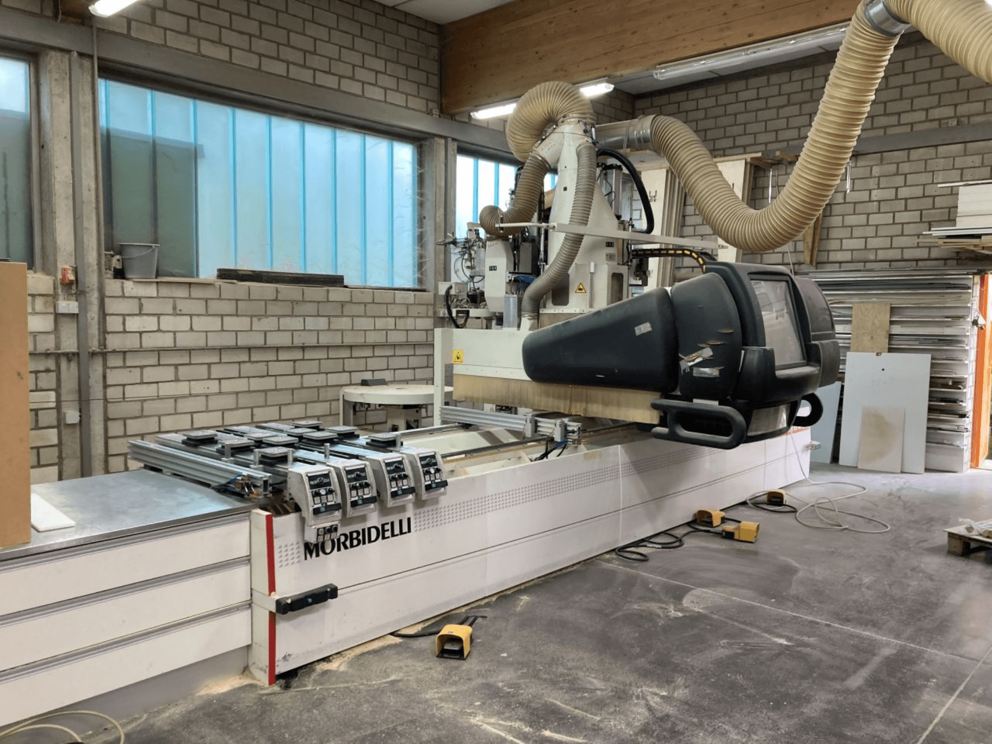 MORBIDELLI CNC-maskin i en verkstad, vy framifrån med kontrollpanel, dammutsugningssystem och trästycke placerat.