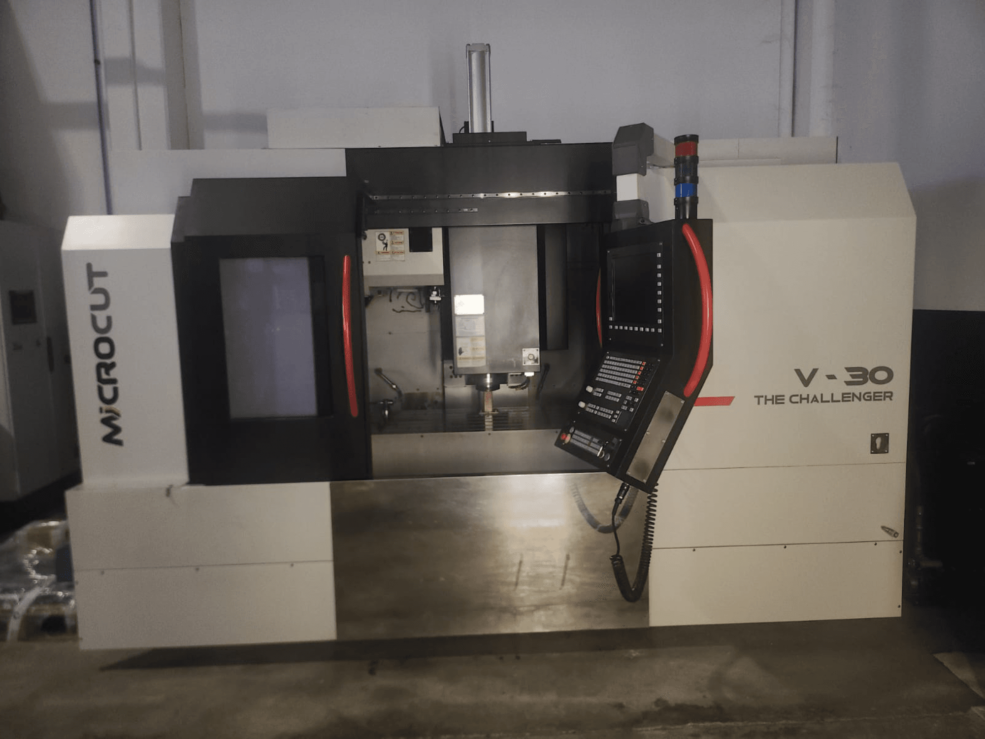 Microcut V-30 CNC-maskinen Challenger, framifrån, med kontrollpanel, skärområde och industriella designelement.