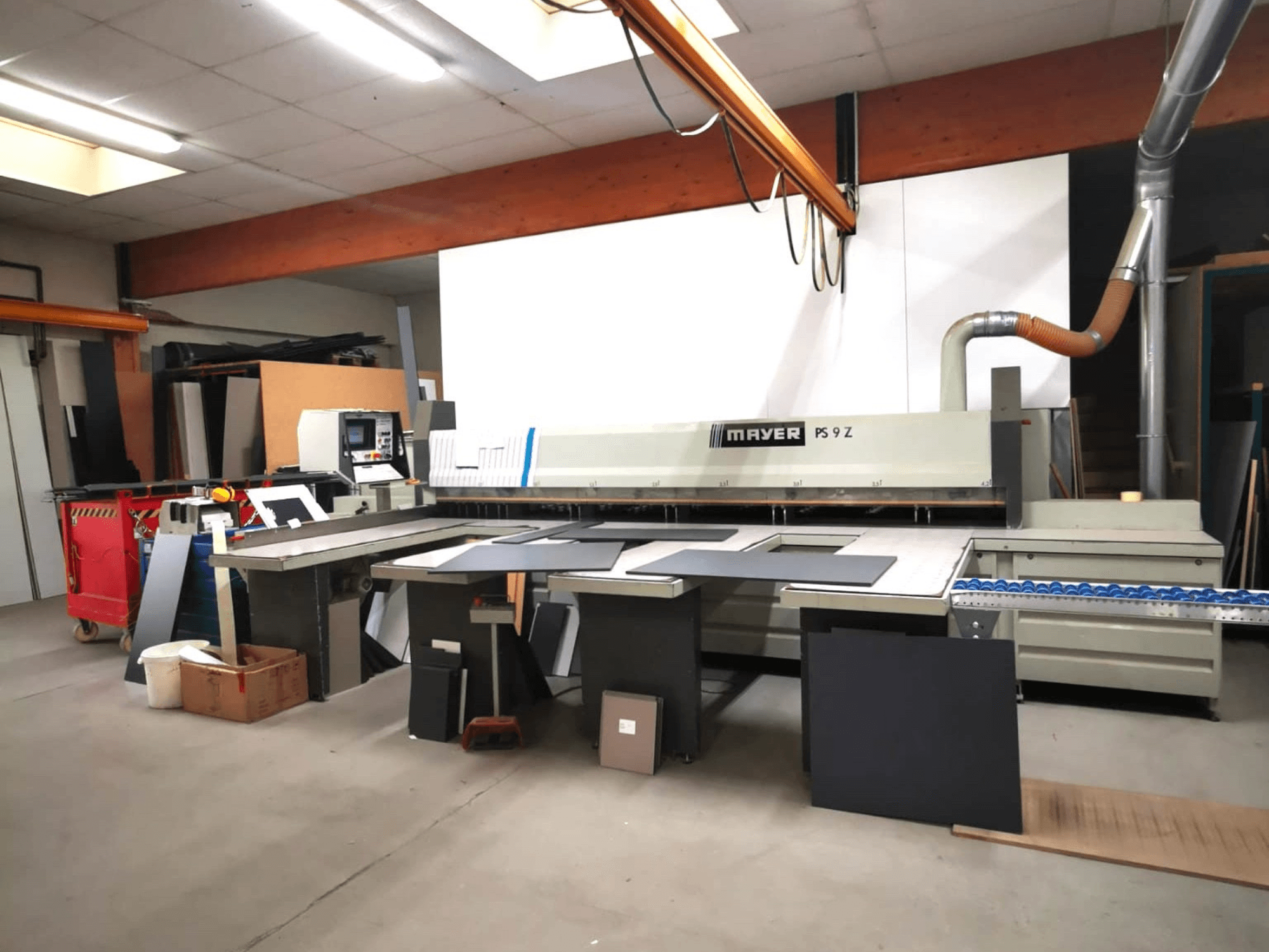 MAYER PS9 Z skärmaskin i en verkstad, vy framifrån, med olika material och ett transportsystem synligt.