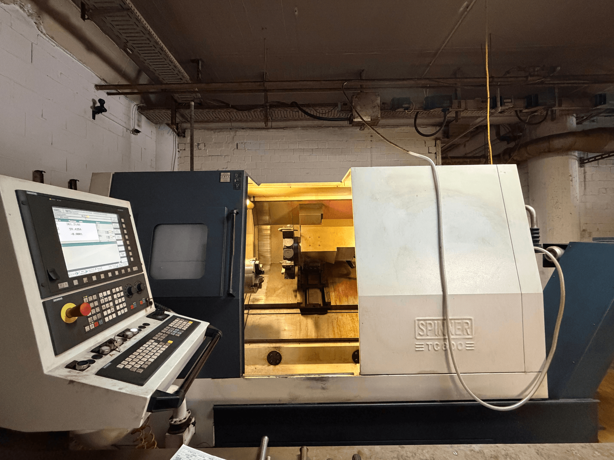 SPINNER TC800 horisontell svarv i en verkstad, med kontrollpanel och synliga interna komponenter.
