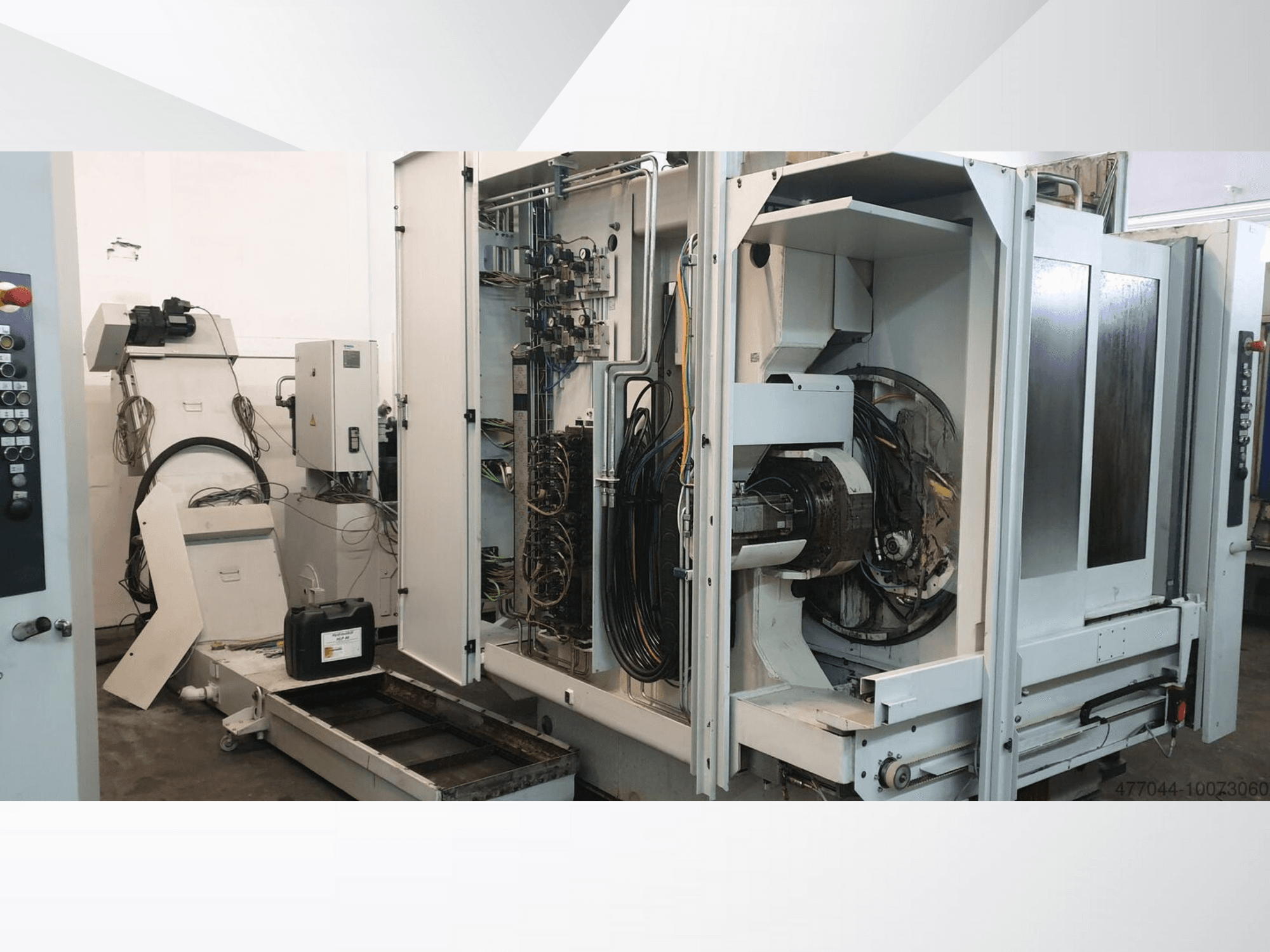 Industriell maskin med synliga ledningar, kontrollpanel och mekaniska komponenter; sidovy av en komplex maskin.