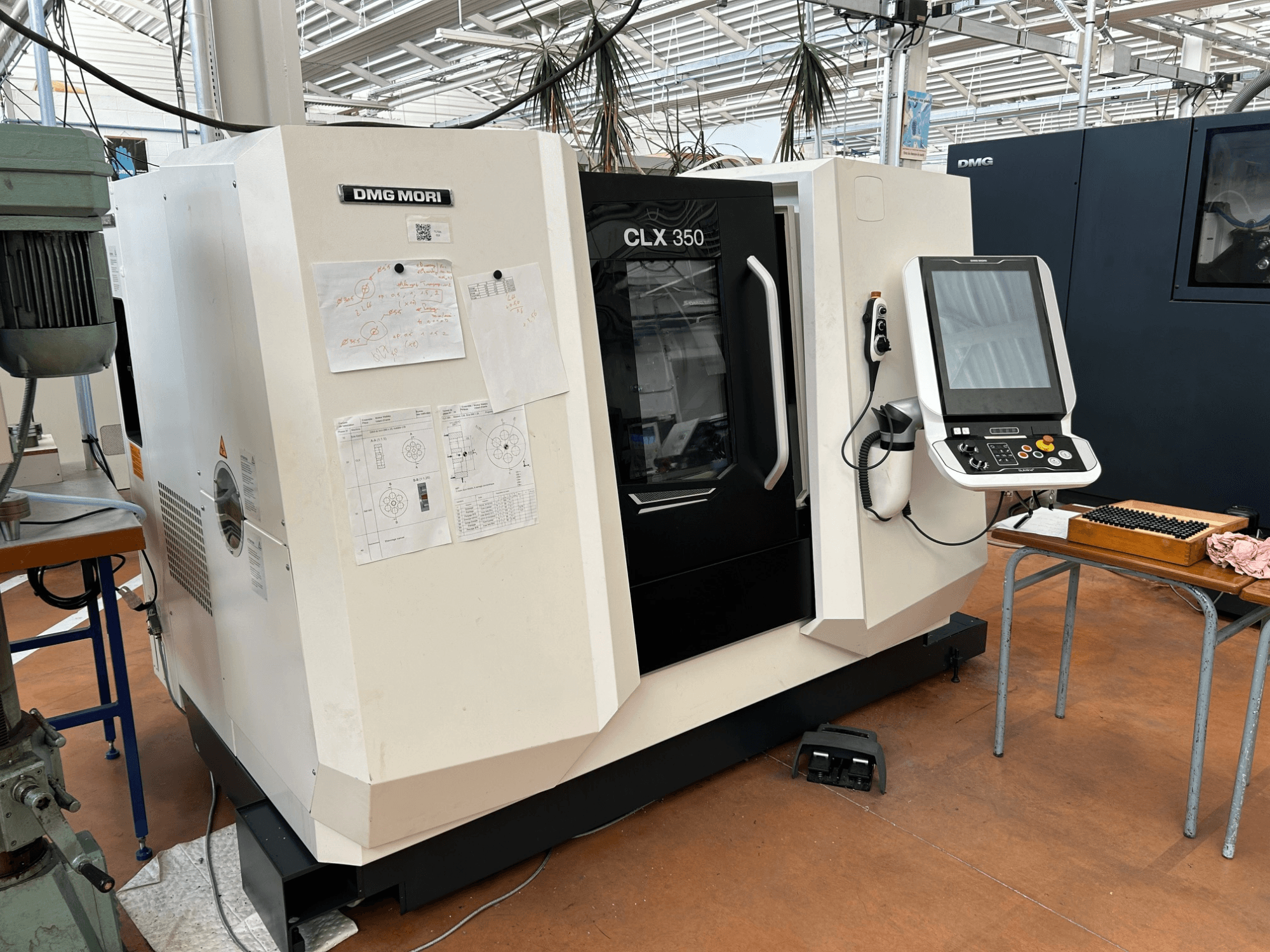 DMG MORI CLX 350 V4 horisontell svarv, framifrån sett med kontrollpanel och bifogade tekniska dokument.