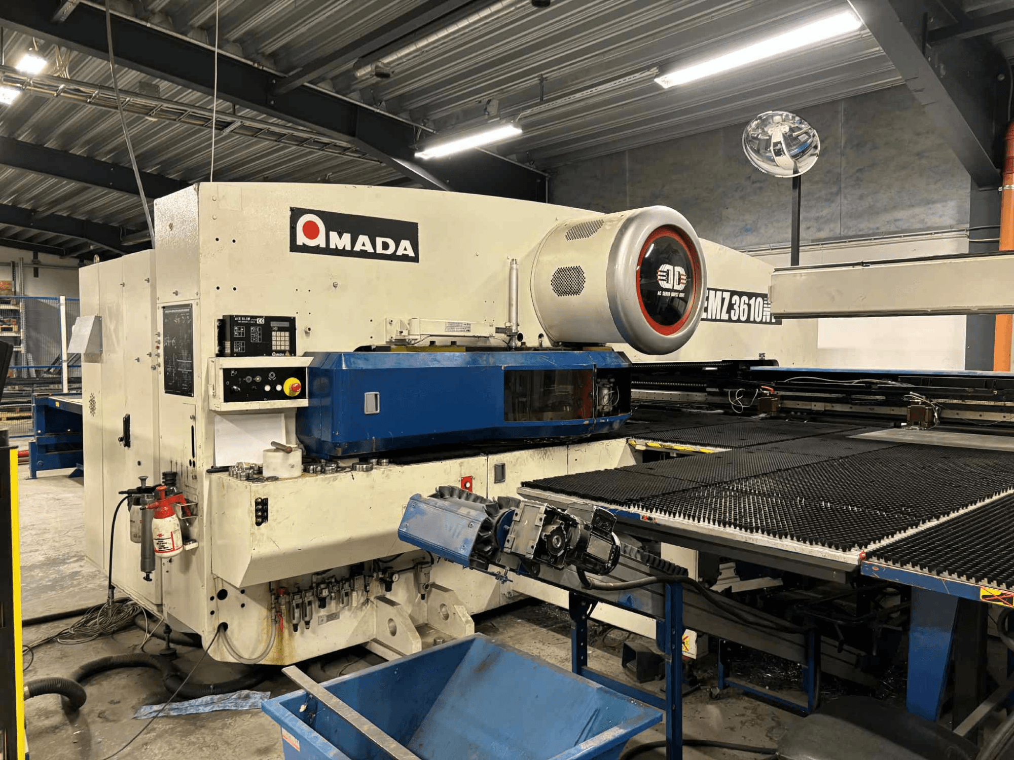 Amada EMZ3610H stansmaskin sedd framifrån; med manöverreglage, blå bädd och säkerhetsutrustning.