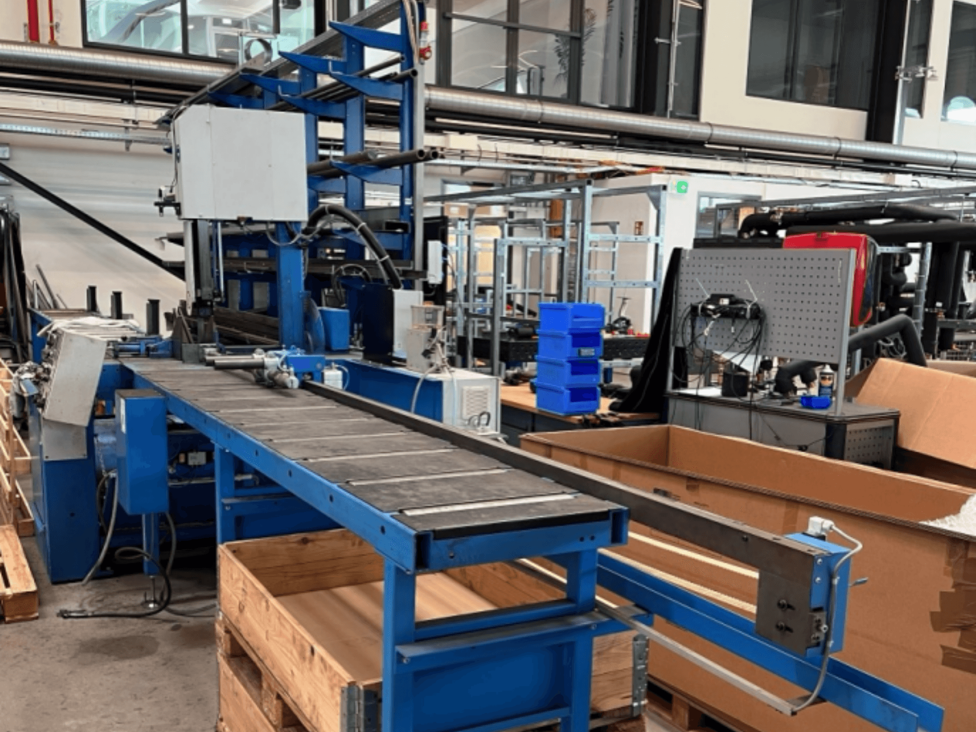 Metallbandsågen JAESPA Classic 423 DGH, sedd framifrån, med ett transportband och omgivande industriutrustning.