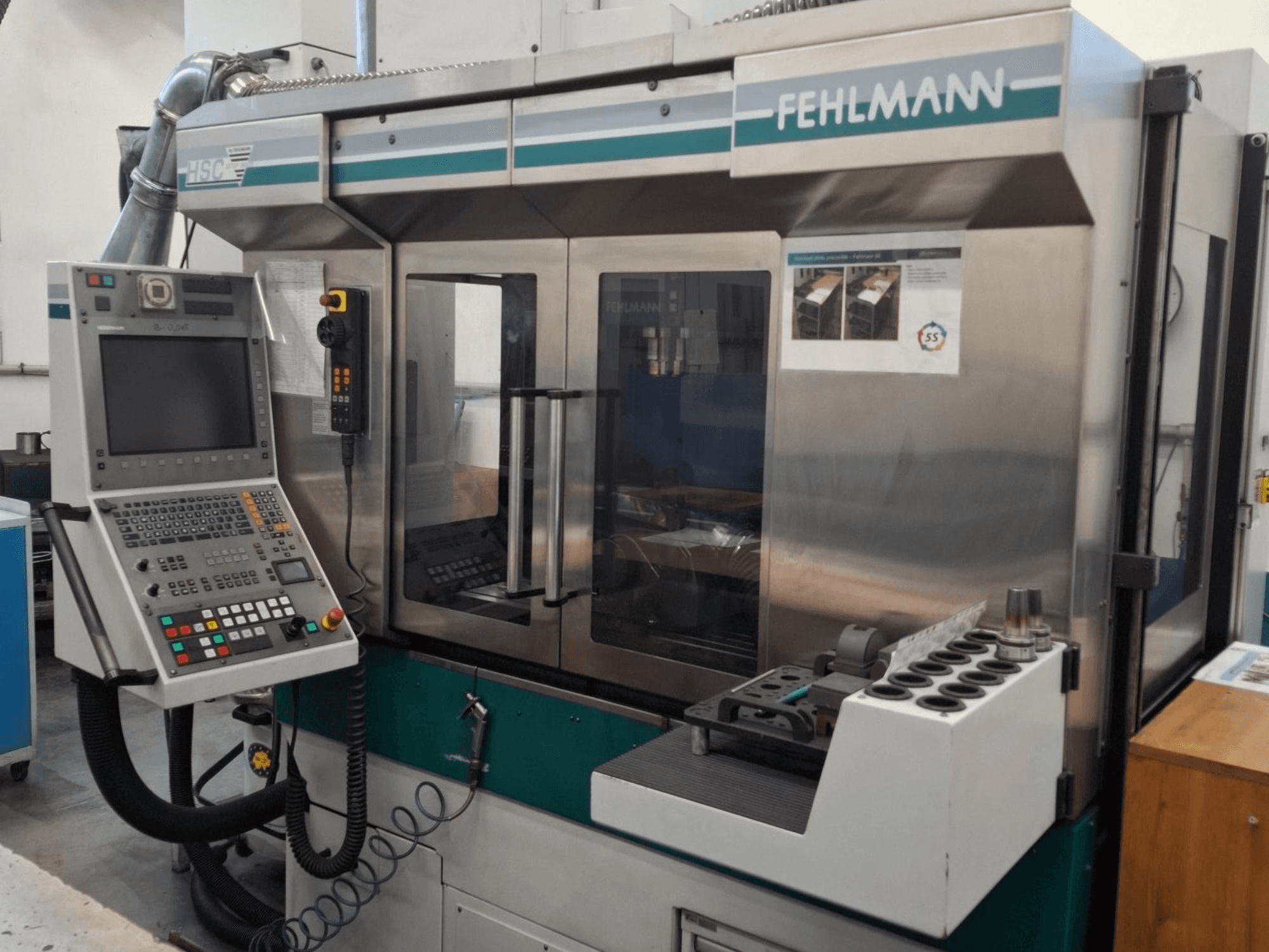 Fehlmann HSC 20 CNC-maskin, framifrån, med kontrollpanel, metallhölje och verktygshållare med flera spår.