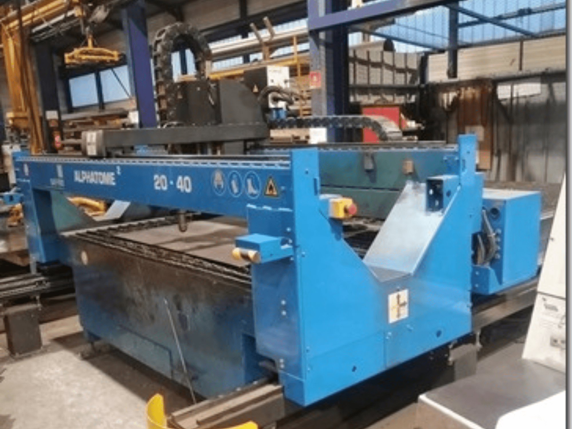 Blå ALPHATOME 20-40 CNC-maskin, framifrån, med skärområdet och kontrollpanelen synliga, konstruerad för precisionstillverkning.